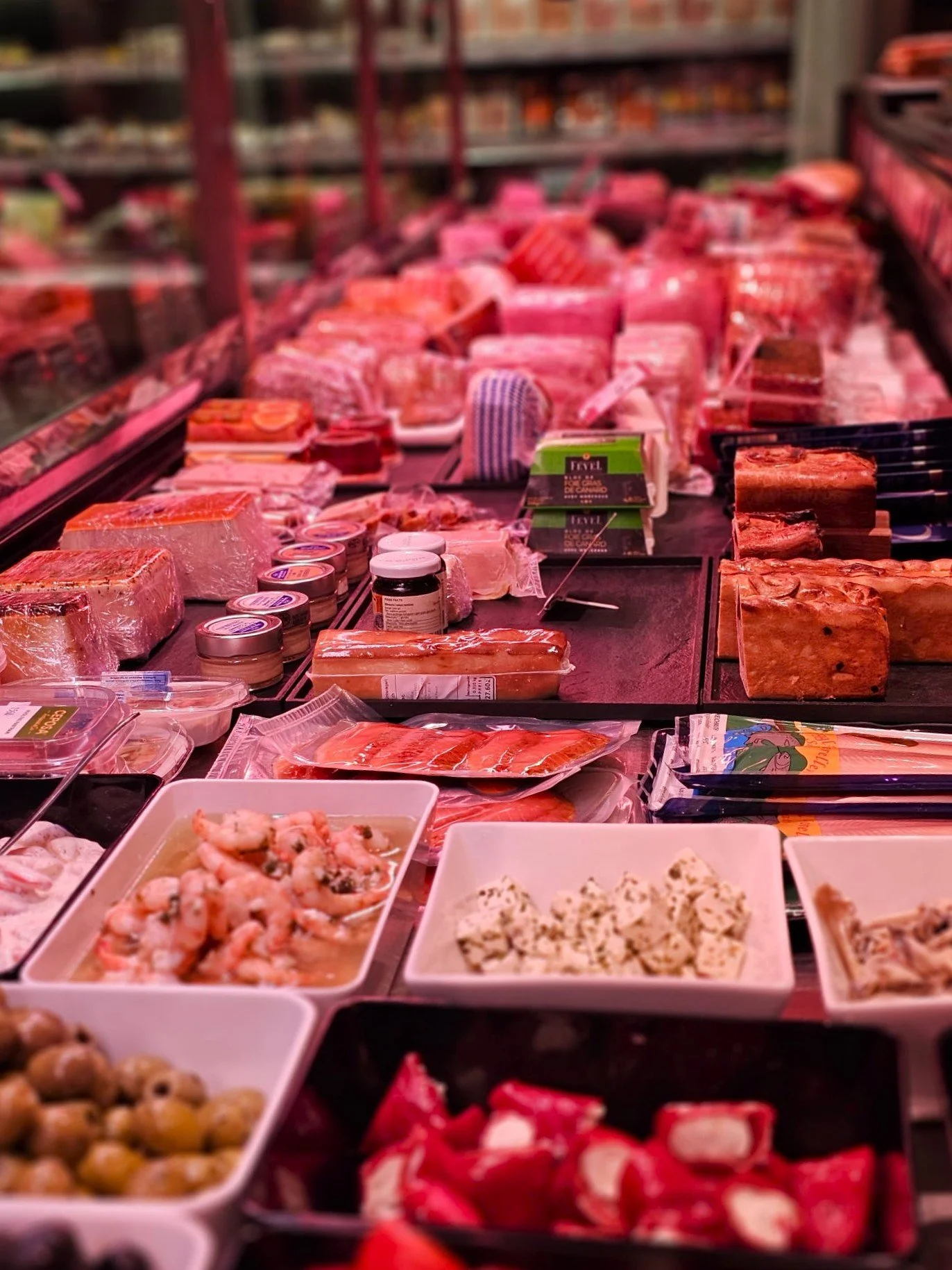 Mamnager Weinregal mit Fleisch- und Wurstwaren in einer Metzgerei.