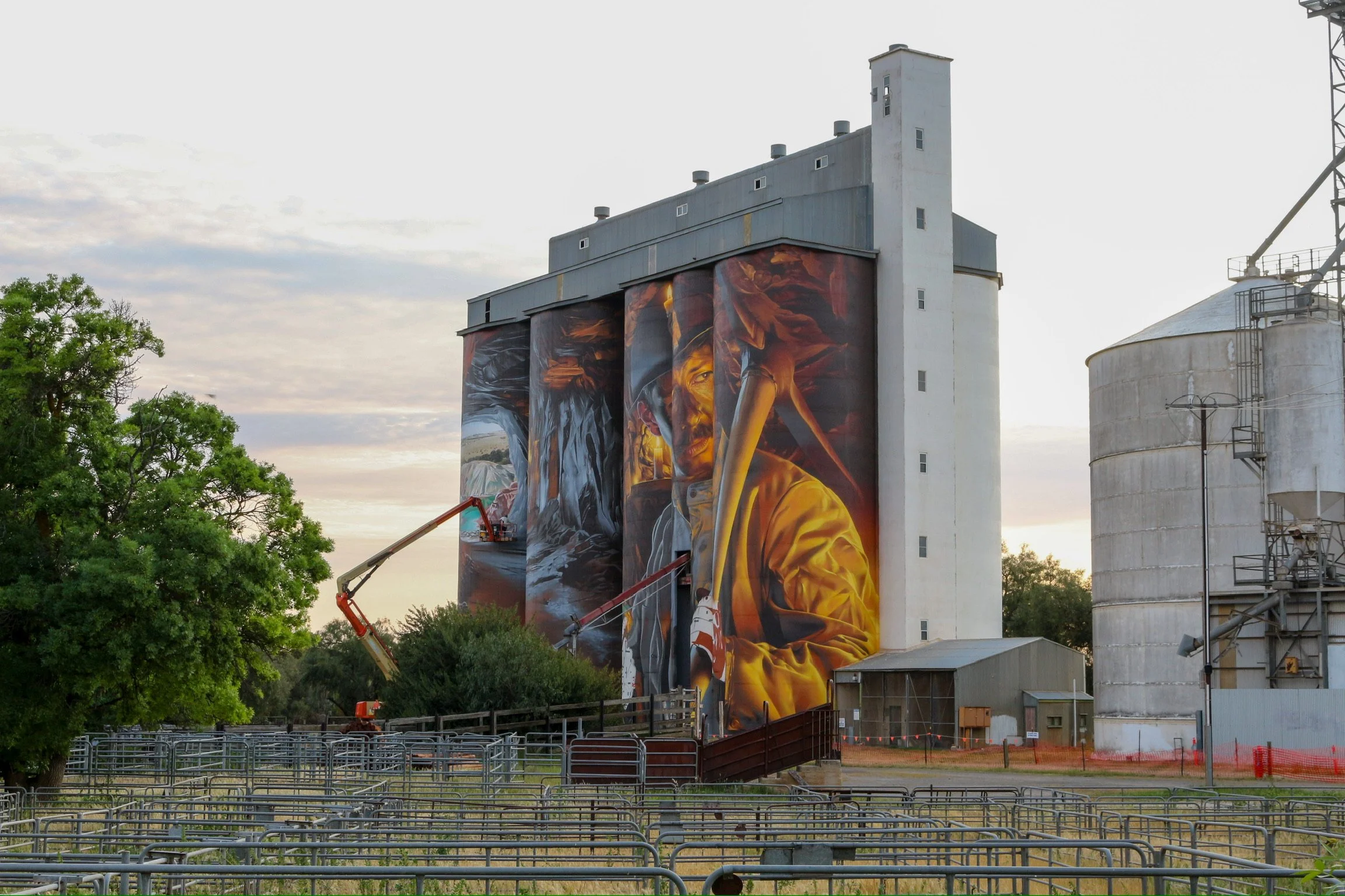 smug art on boom painting silo art as the sun sets