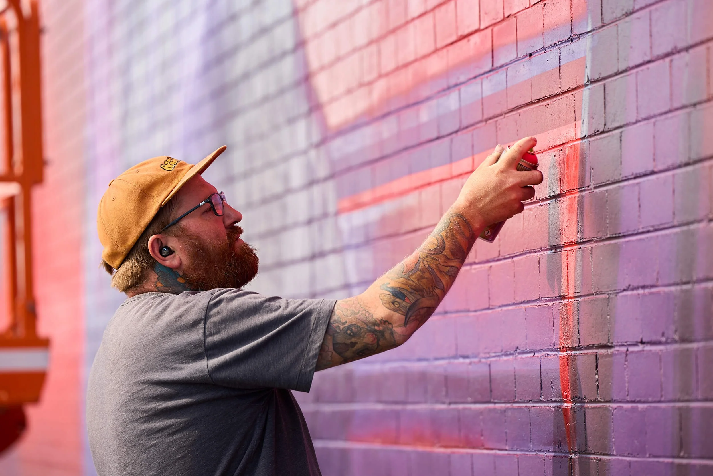 a street artist painting a mural with a spray can