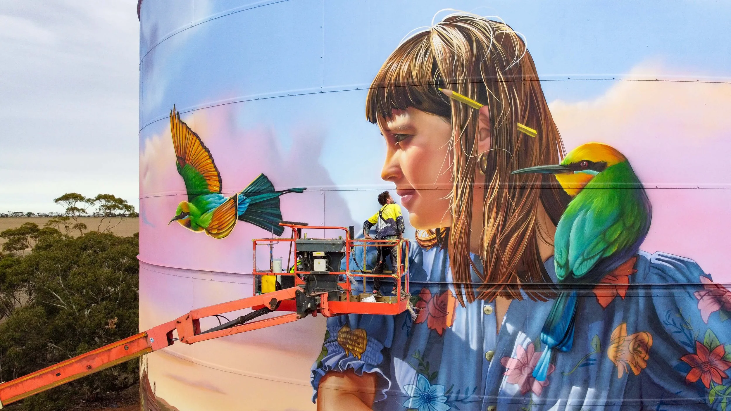 image of an artist painting a portrait of a young girl on her bike on a grain silo