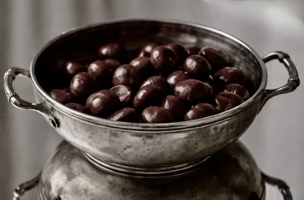 Heritage inspiration - a silver bowl of chestnuts referencing the chestnut tree emblem threaded through CASTELLAINES.