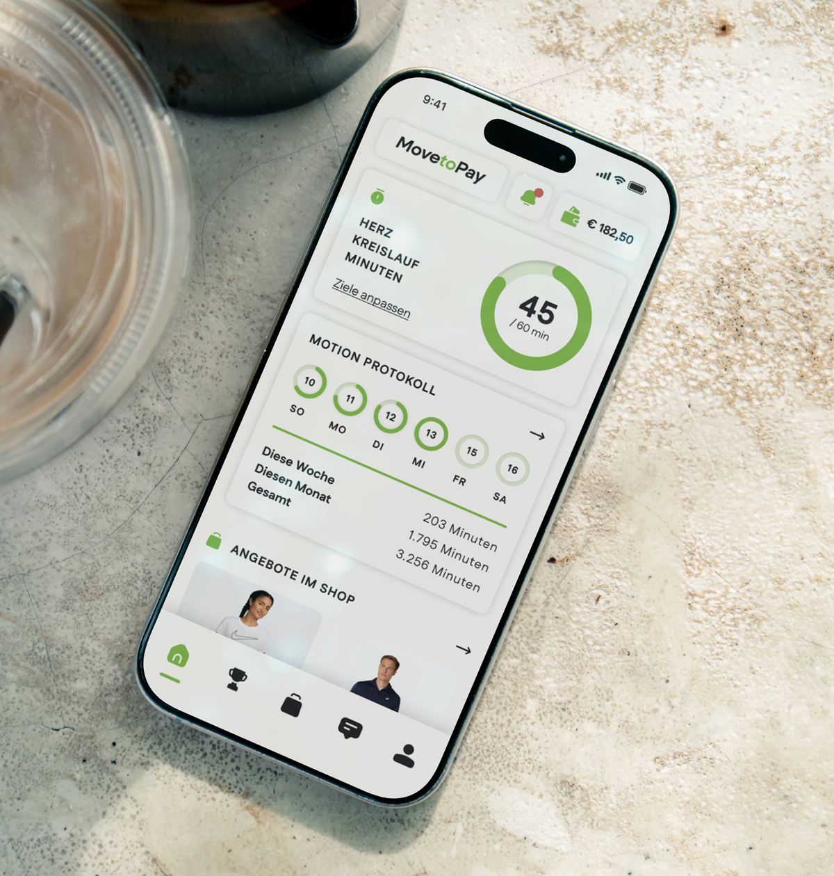 Smartphone auf einem Tisch mit Move to Pay-App, zeigt Workout-Details, einen Timer und Trainingsprotokoll.