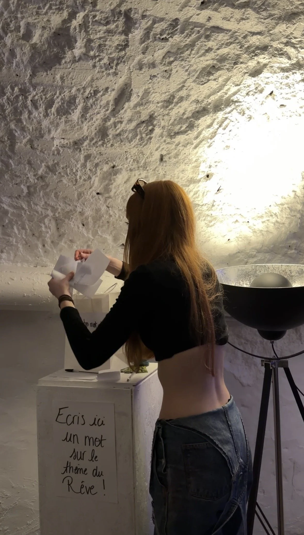 Manon va chercher les mots des visiteurs pour les notés sur une toile, lors d'un événement dans un concert store. Live painting & DJ set