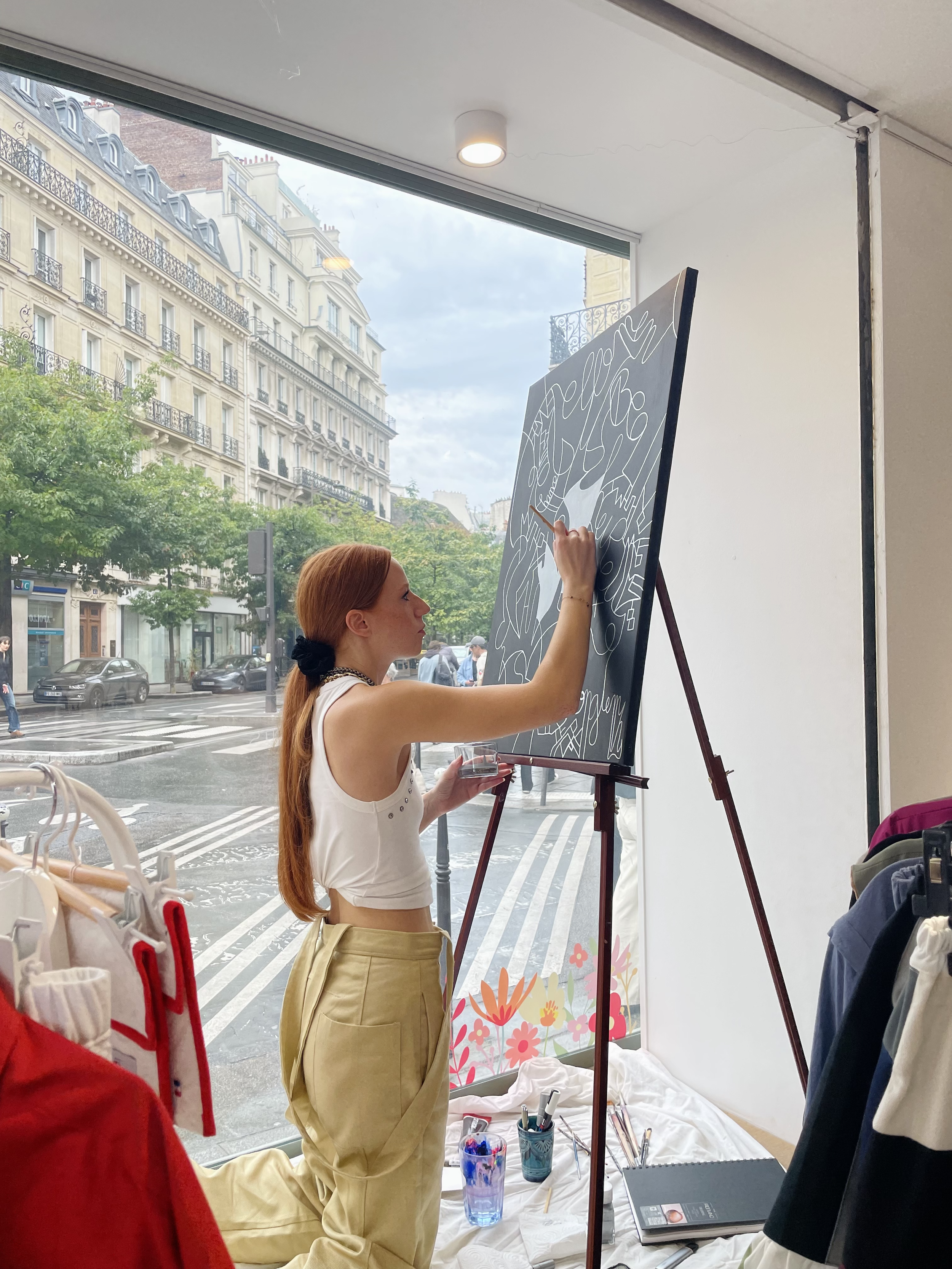 L'artiste peintre, Manon SAJOUS, qui peint dans la vitrine d'un pop up à Paris. 