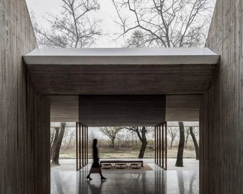 A person walking with purpose through the entrance of a sleek, modern building — symbolizing the decision to build a business rooted in personal clarity and strategic coherence.