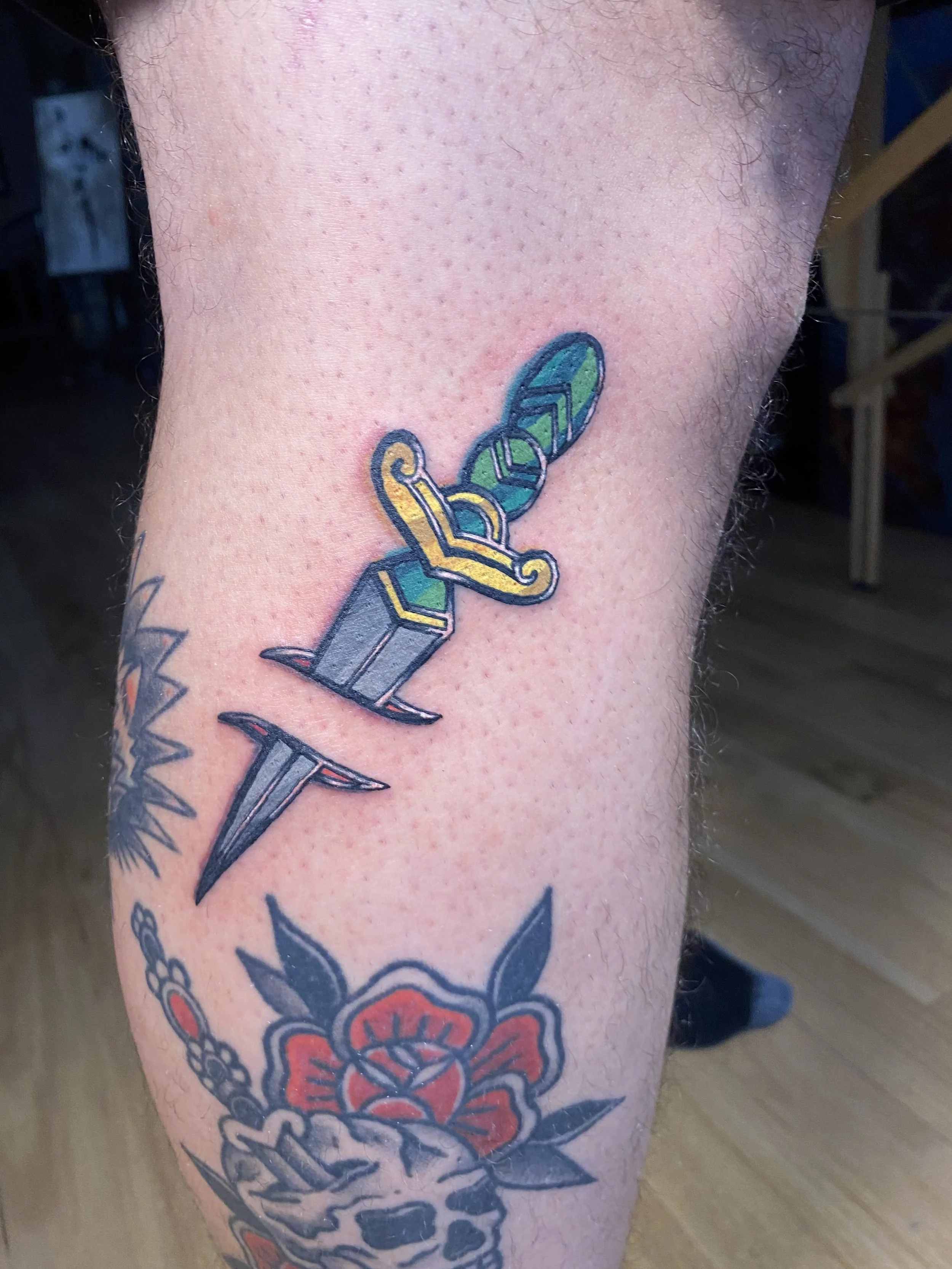 Full color American traditional dagger tattoo in a stained glass style