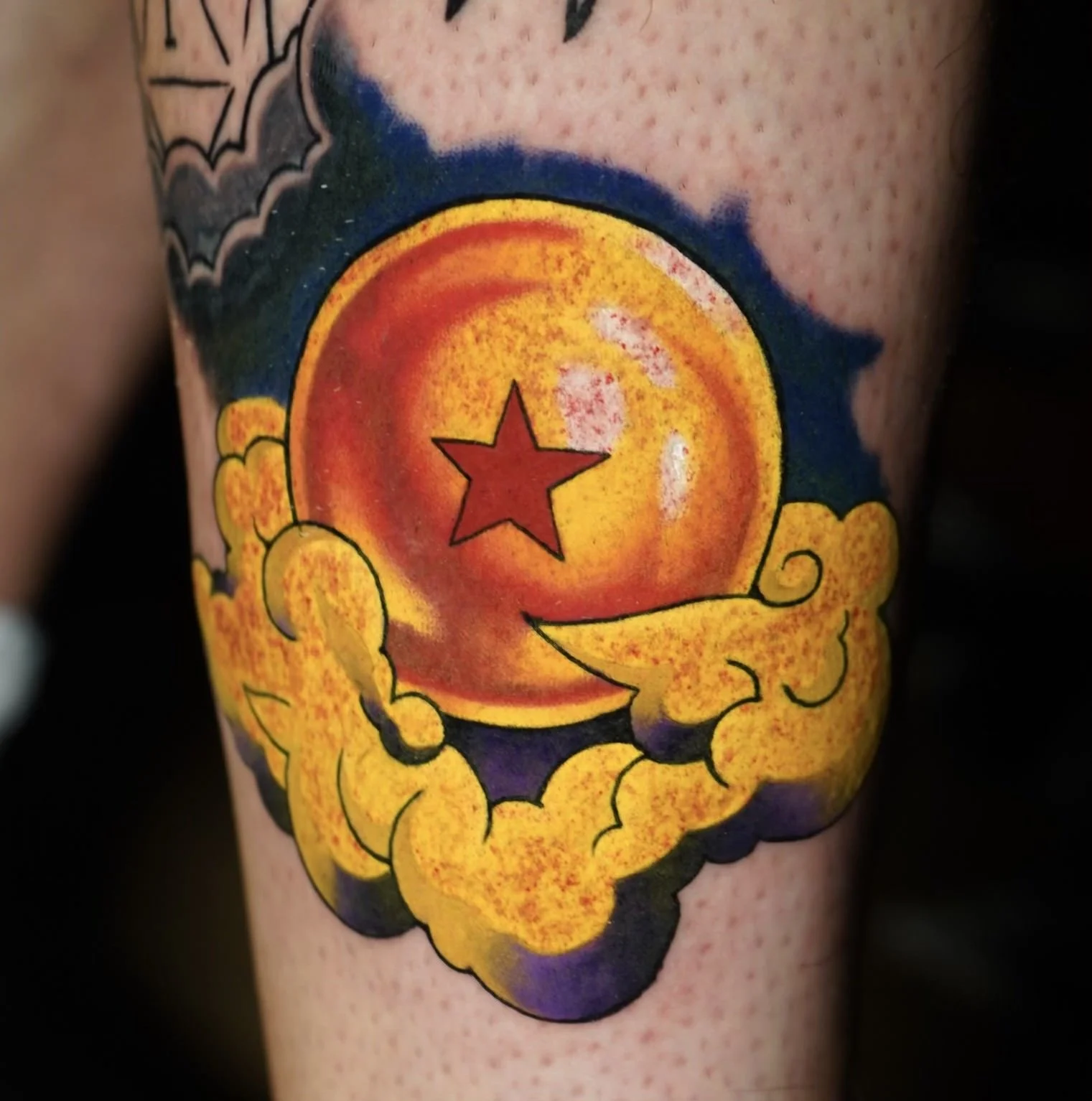 Dragon ball Z anime tattoo with saturated red and yellows, purple shading, crisp lines, high contrast