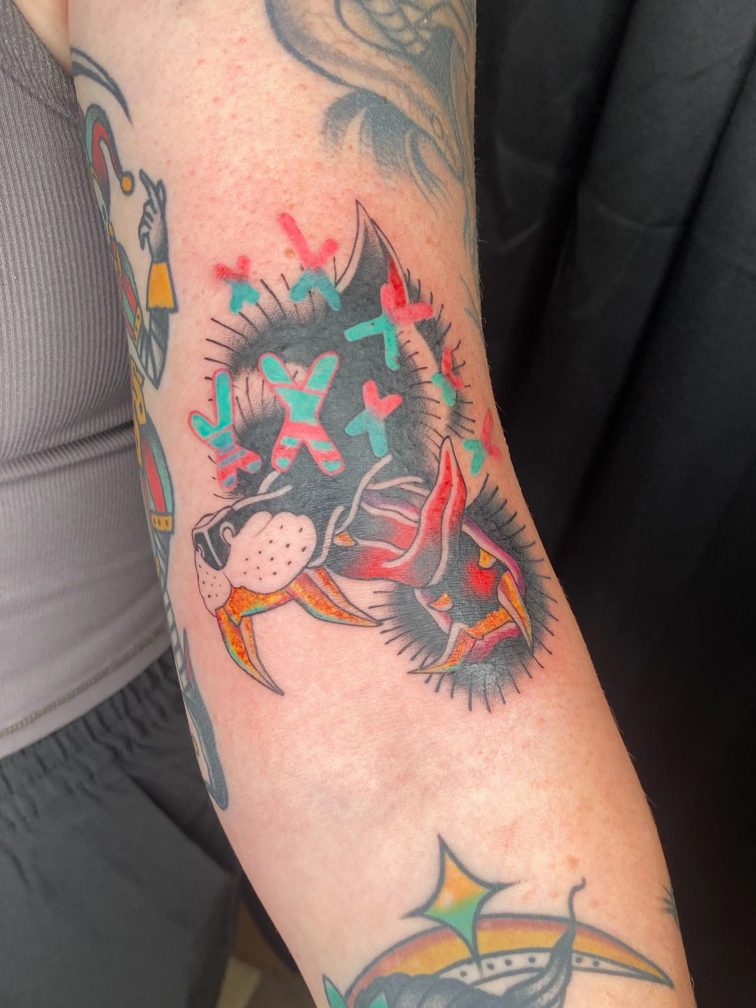 American Traditional-inspired wolf tattoo with psychedelic elements by Denver tattoo artist Joshua Socrates in RiNo.