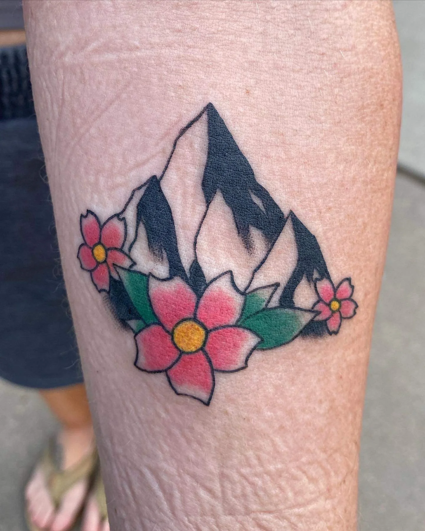 Traditional tattoo of mountains and flowers