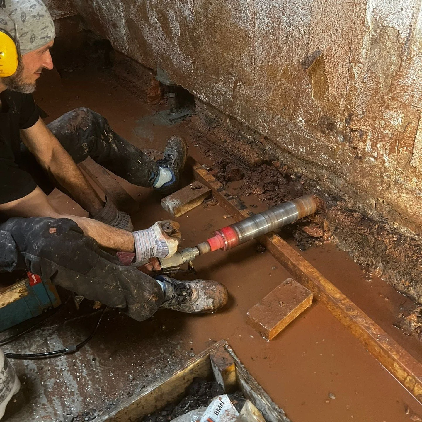 Inkassingen boren in de bouwmuur. Dit zodat de bouwmuur zo gedragen kan worden door de nieuwe fundering.