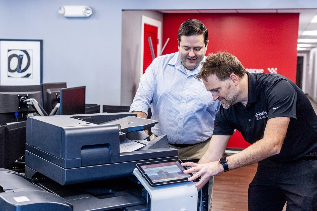 two men fix a printer copier in Innovative's office