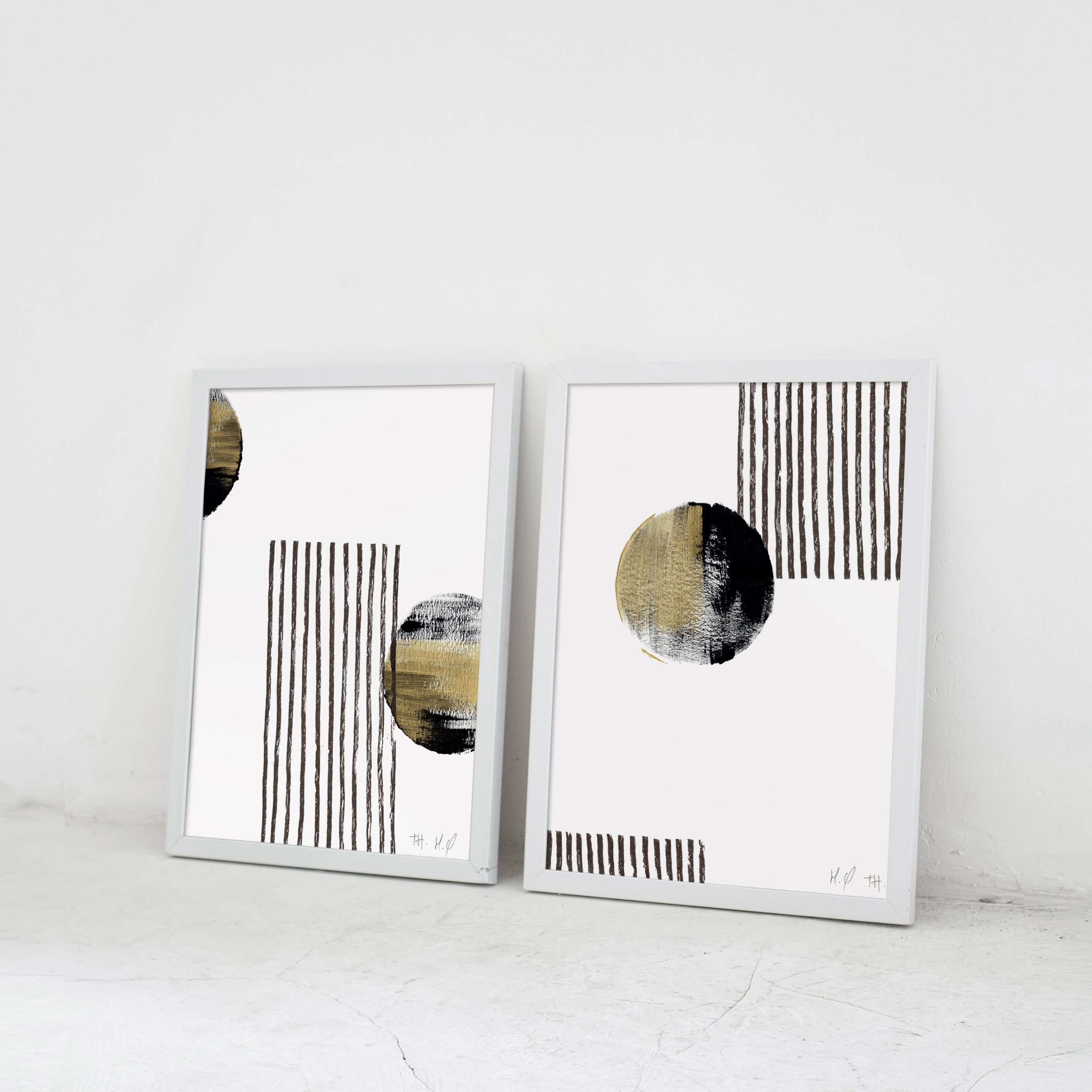 Deux tableaux abstraits avec des cercles et des lignes noirs et dorés sur fond blanc.