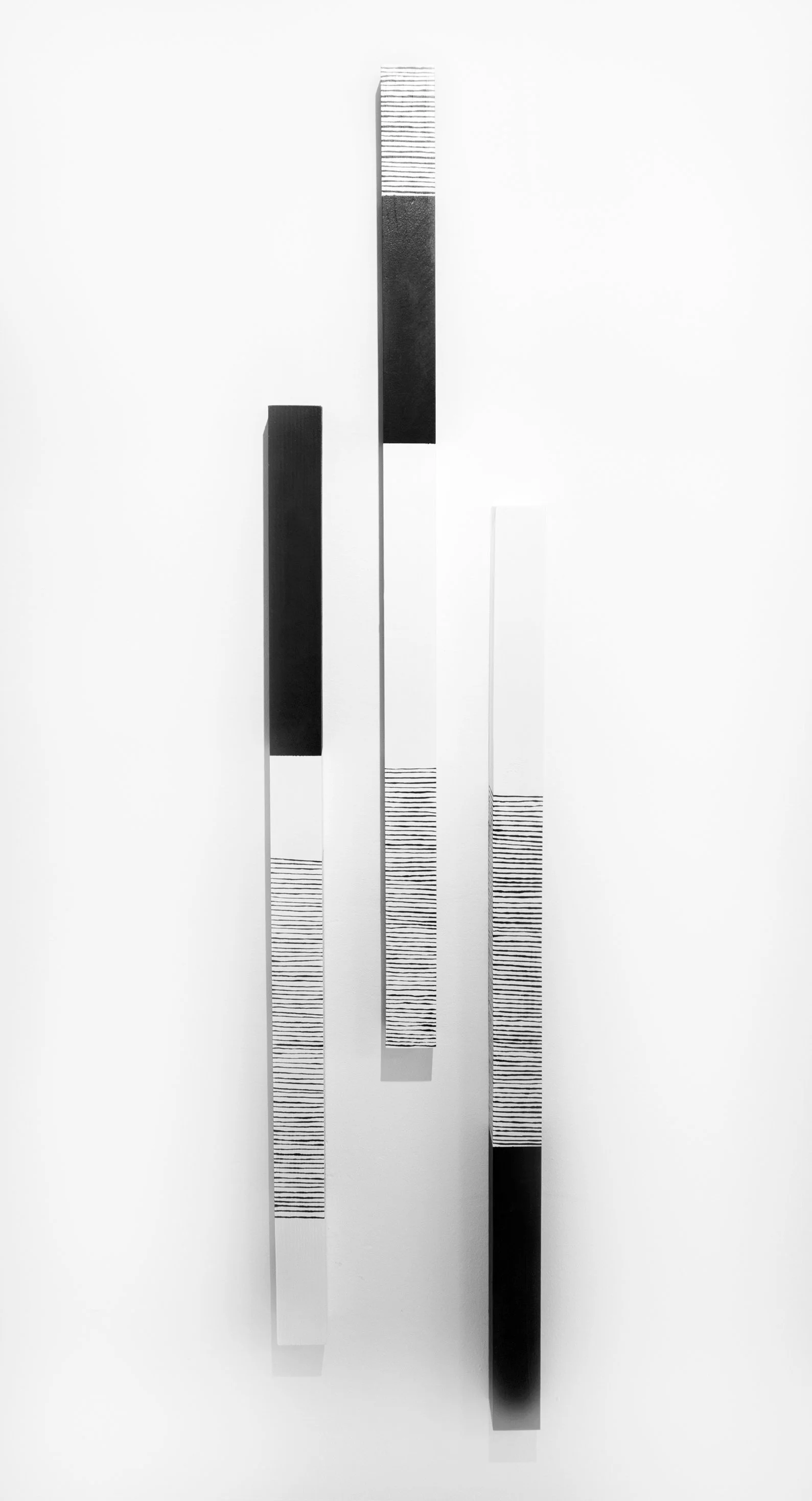 Abstract black and white artwork with vertical rectangular bars of varying heights and patterns, including solid black, white with black horizontal lines, and plain white.