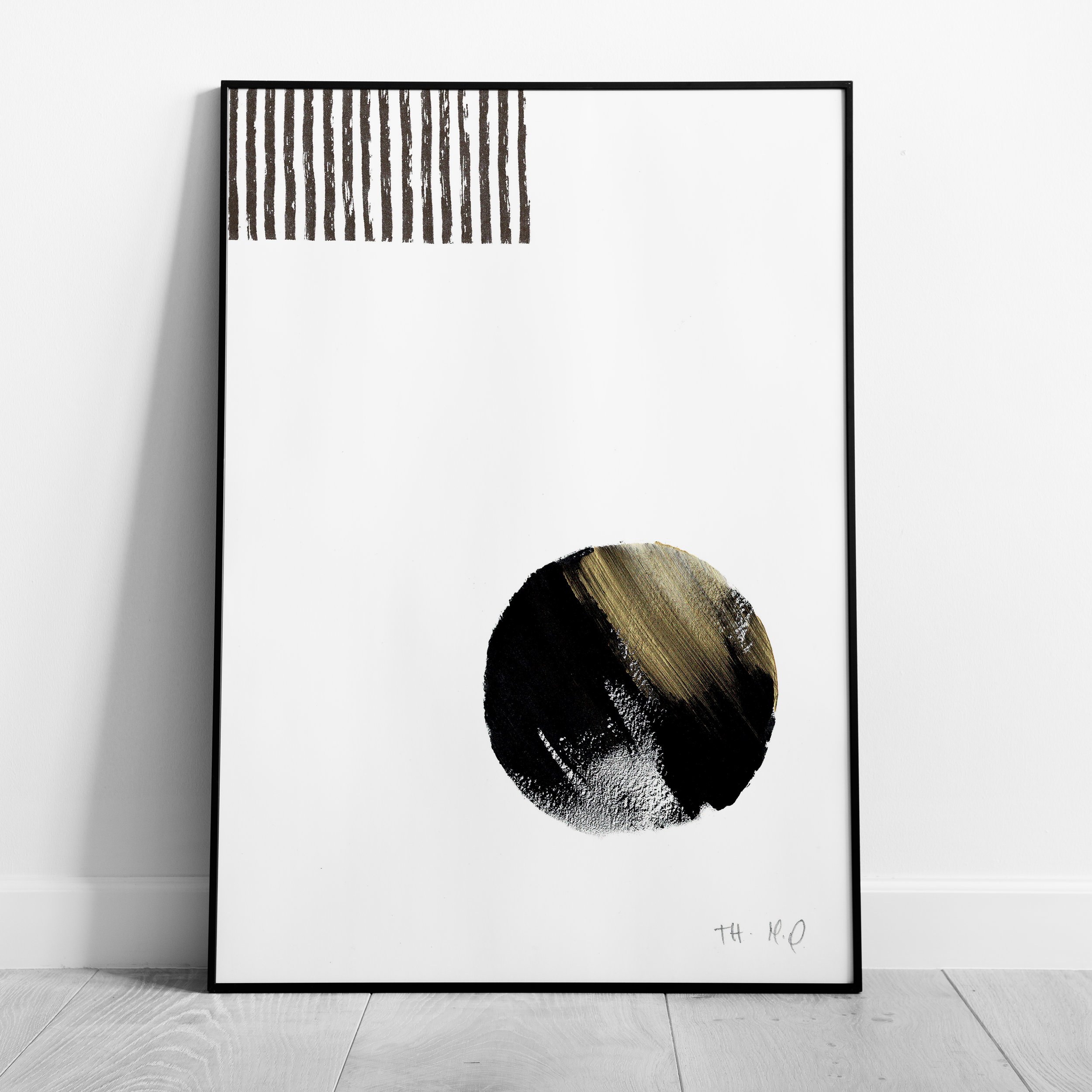Minimaliste, la photo montre un cadre posé sur le sol, contenant une œuvre d'art abstraite. L'œuvre présente des rayures verticales en haut à gauche et un cercle noir avec des nuances dorées au centre.