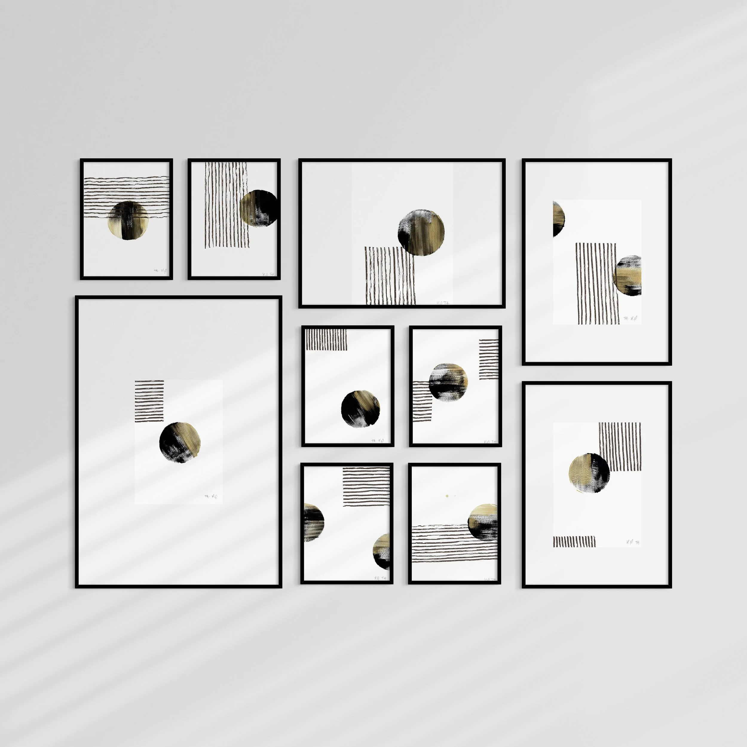 Mur avec un ensemble de cadres photo minimalistes contenant des illustrations abstraites en noir, blanc et or.