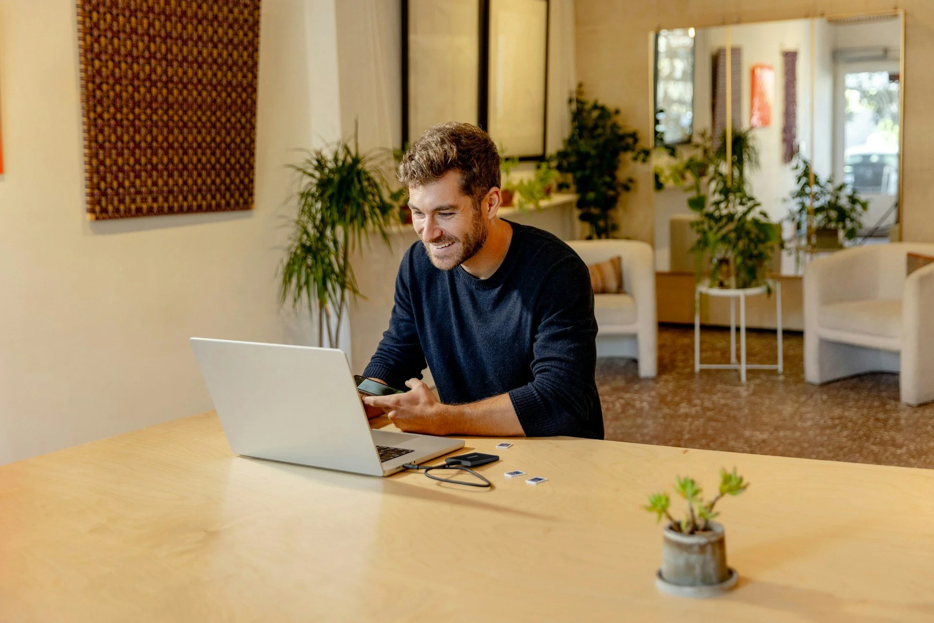 man at laptop smiling as hey engages with someone on a video call
