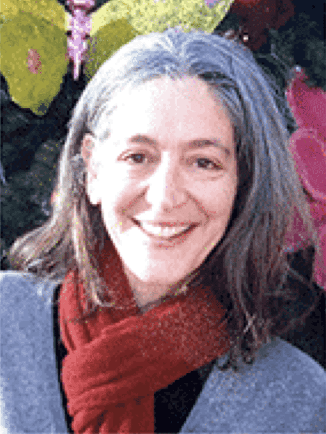 Colette Lafia, spiritual director and artist, smiling, wearing a red scarf, with flowers behind her.