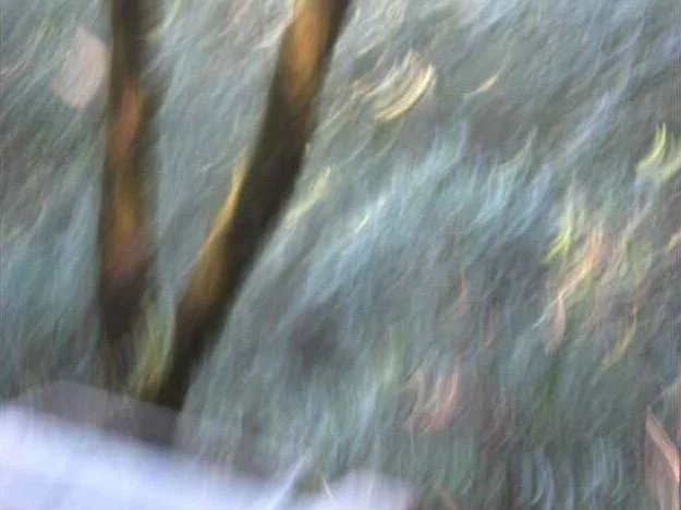 A blurry photo of streaks of color and light amid a mostly grey background.