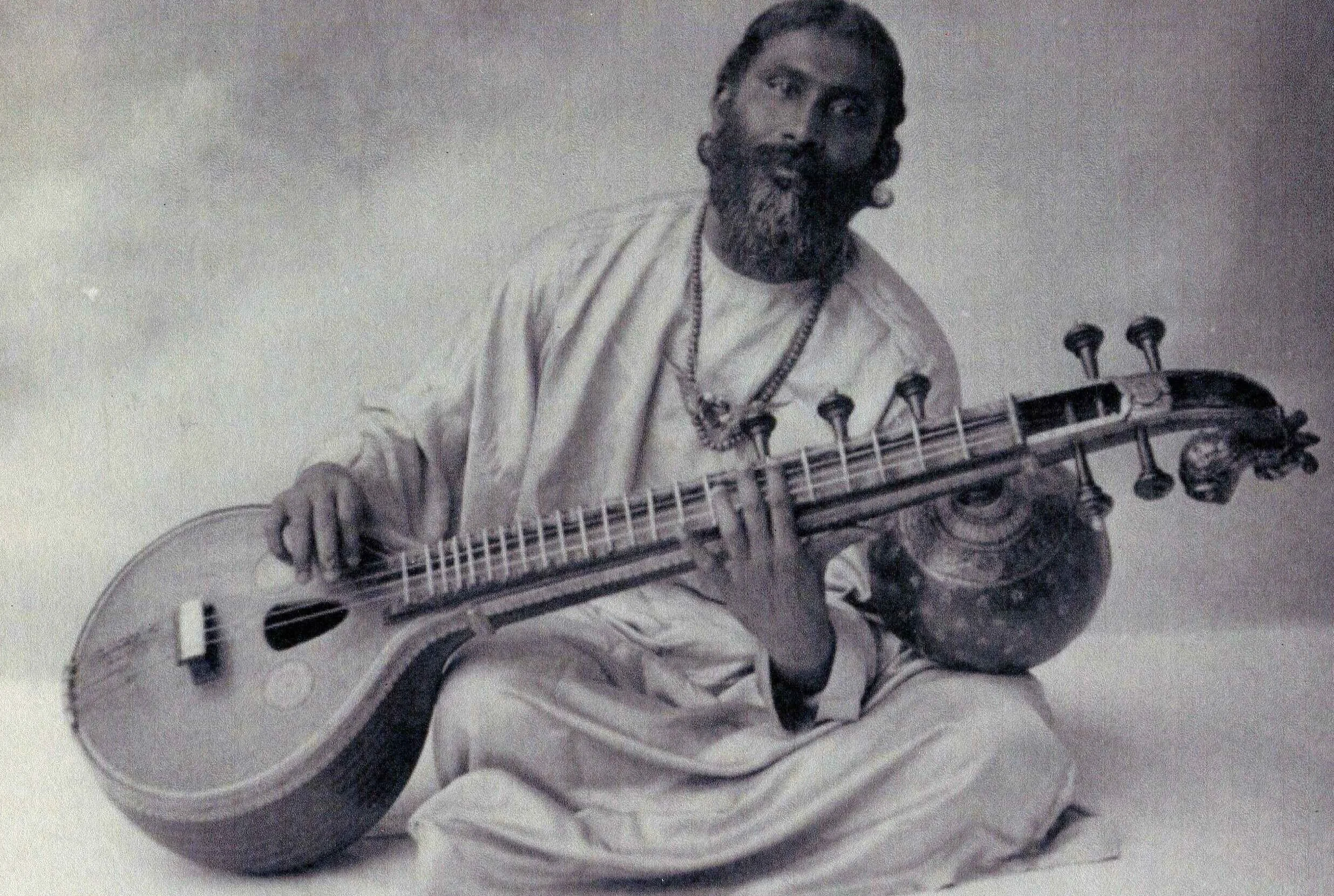 Historical portrait of Sufi master Hazrat Inayat Khan with his vina, captured in contemplative musical practice