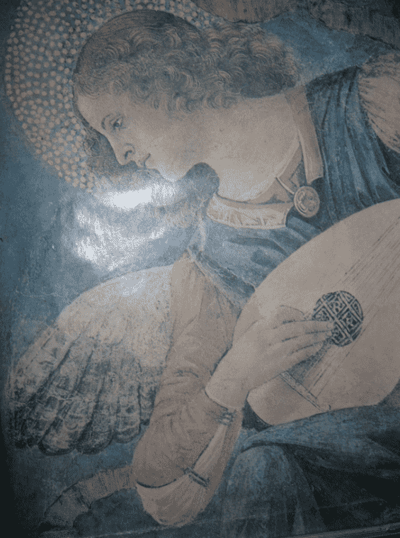 Detail of an old painting: an angel with curly hair and a halo, playing a lute.