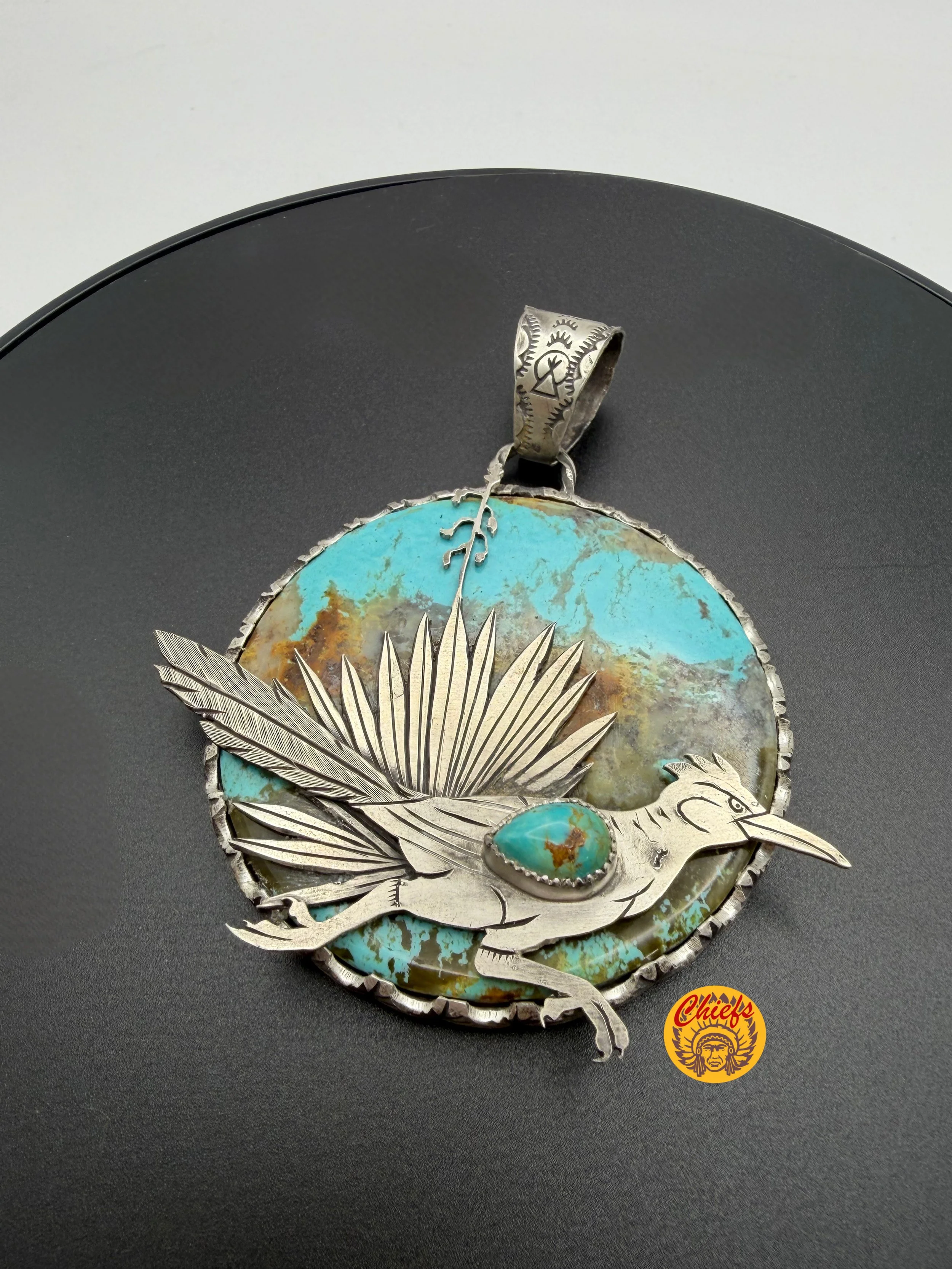 Roadrunner Statement Pendant

A true statement of Southwest artistry, this handcrafted pendant features a striking slab of Number 8 turquoise, known for its vivid blue tones and rich, earthy matrix. Set against the natural stone backdrop, a finely de