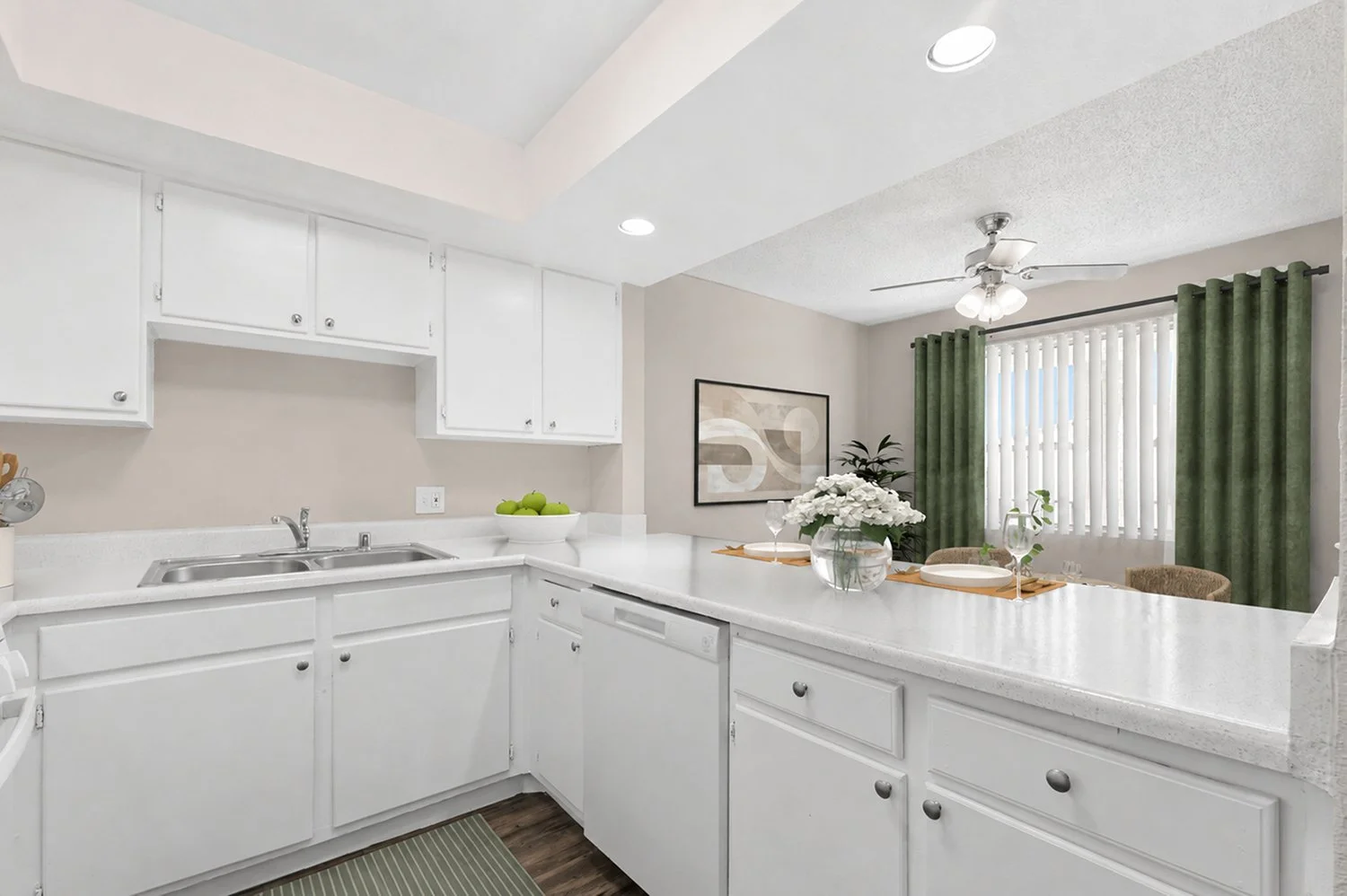 updated kitchen in Andorra 2 Bedroom apartment with wood-style plank flooring, white cabinetry, white appliances, and plenty of counter and storage space. 