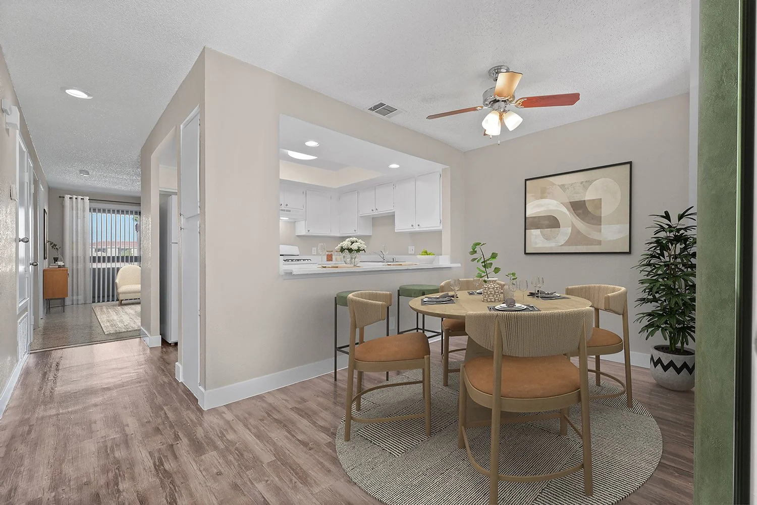 Dining nook in Andorra 2 Bedroom apartment home with wood-style plank flooring, large window, area for stools at the countertop and overhead ceiling fan. 