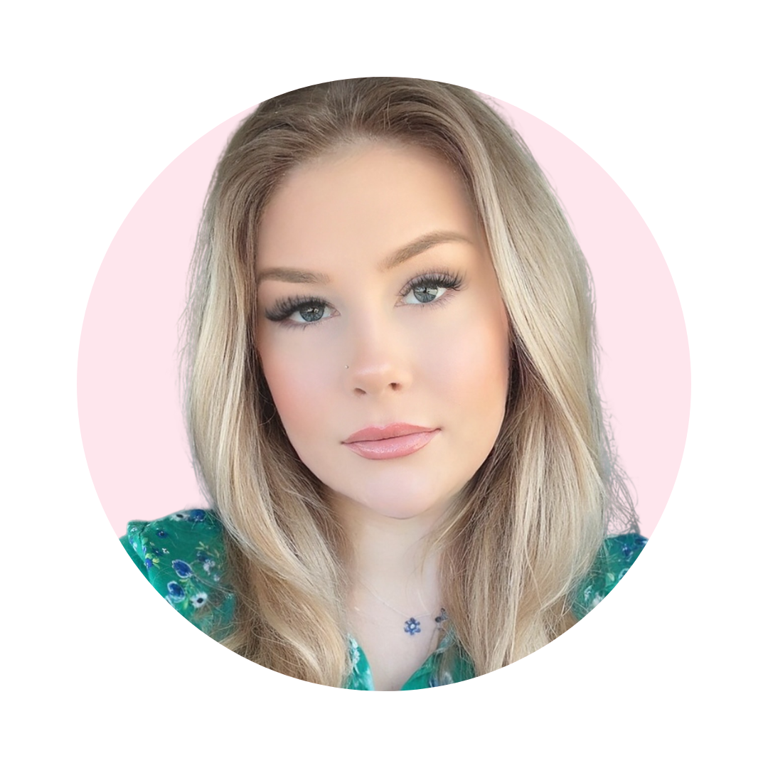 A portrait of a young woman with long blonde hair, light makeup, and blue eyes, wearing a green top with floral patterns, against a pink background.