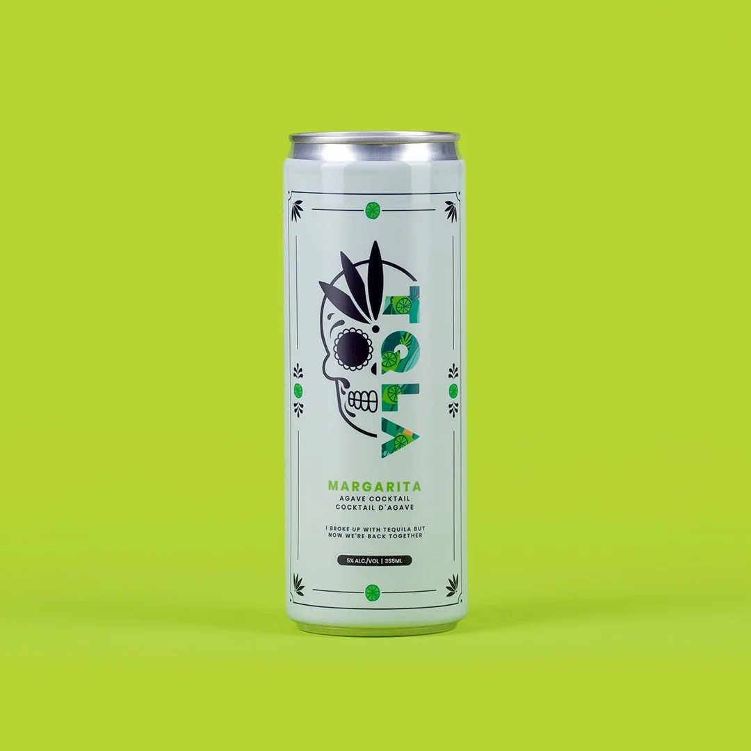 A tall, narrow can of Margarita agave cocktail with a colorful and artistic skull logo on a bright green background.