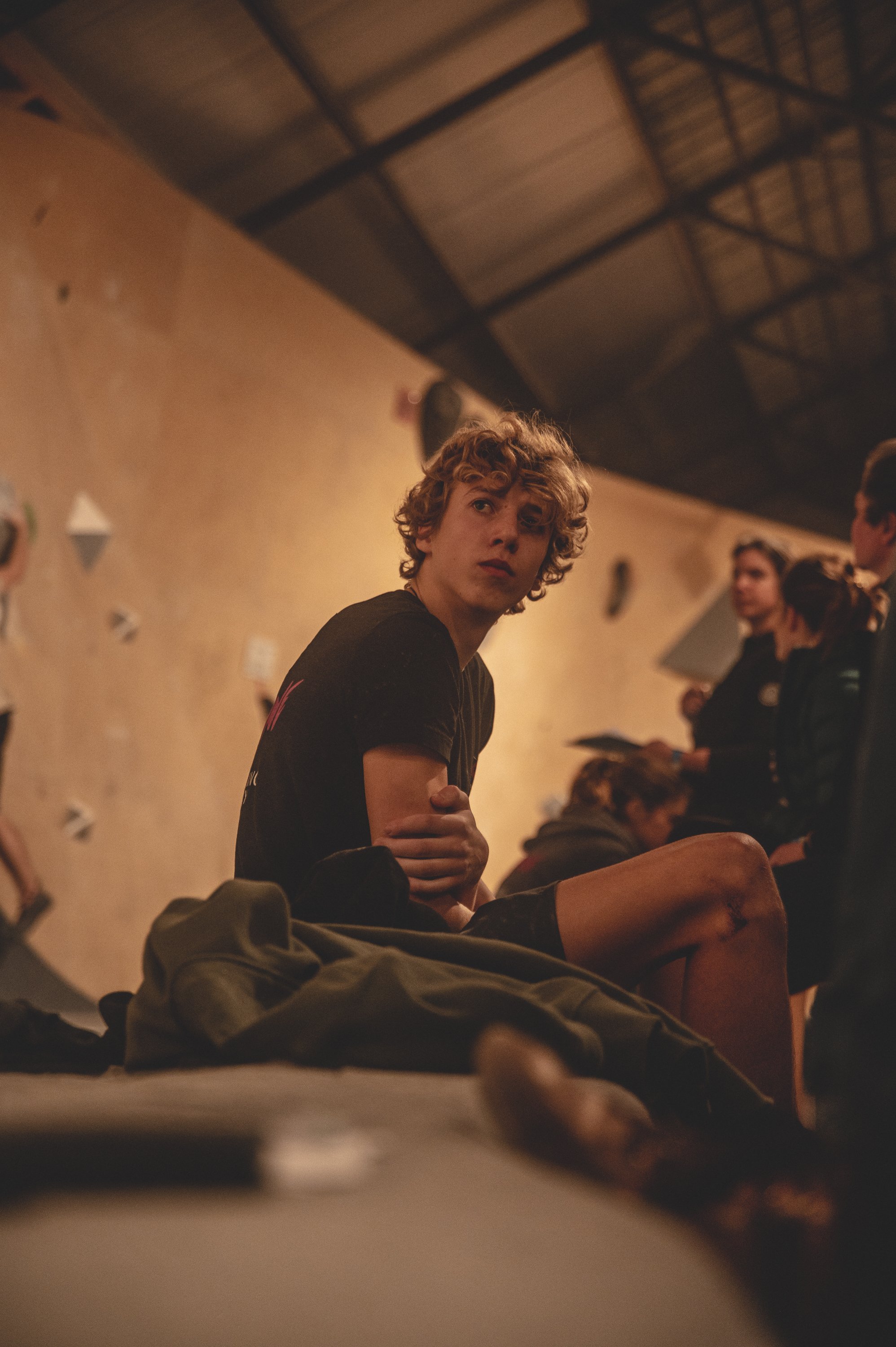 L'escalade de bloc est un sport qui demande une grande force physique, une agilité exceptionnelle, mais aussi une concentration mentale à toute épreuve. Ce jeune athlète, assis dos au bloc, en est la parfaite illustration. Dans l'attente de son tour,