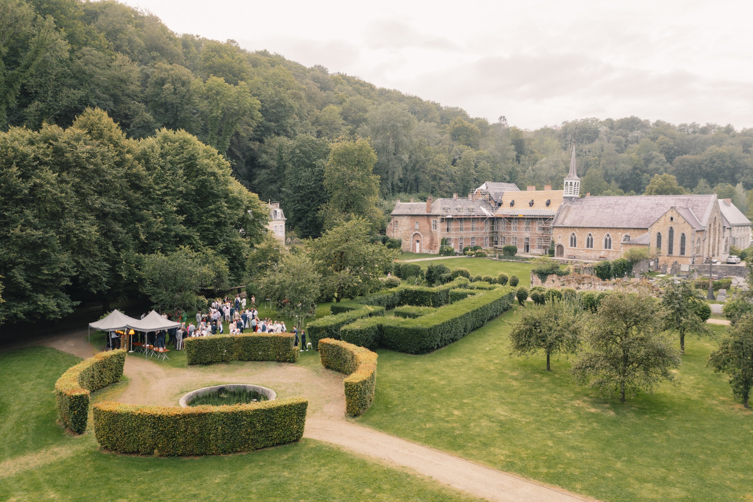 L'Abbaye Notre-Dame du Vivier, un lieu magique pour un mariage inoubliable. Julien Mathy, photographe de mariage attentif et discret, a capturé cette vue d'ensemble exceptionnelle où les invités, réunis dans ce cadre enchanteur, célèbrent l'union de