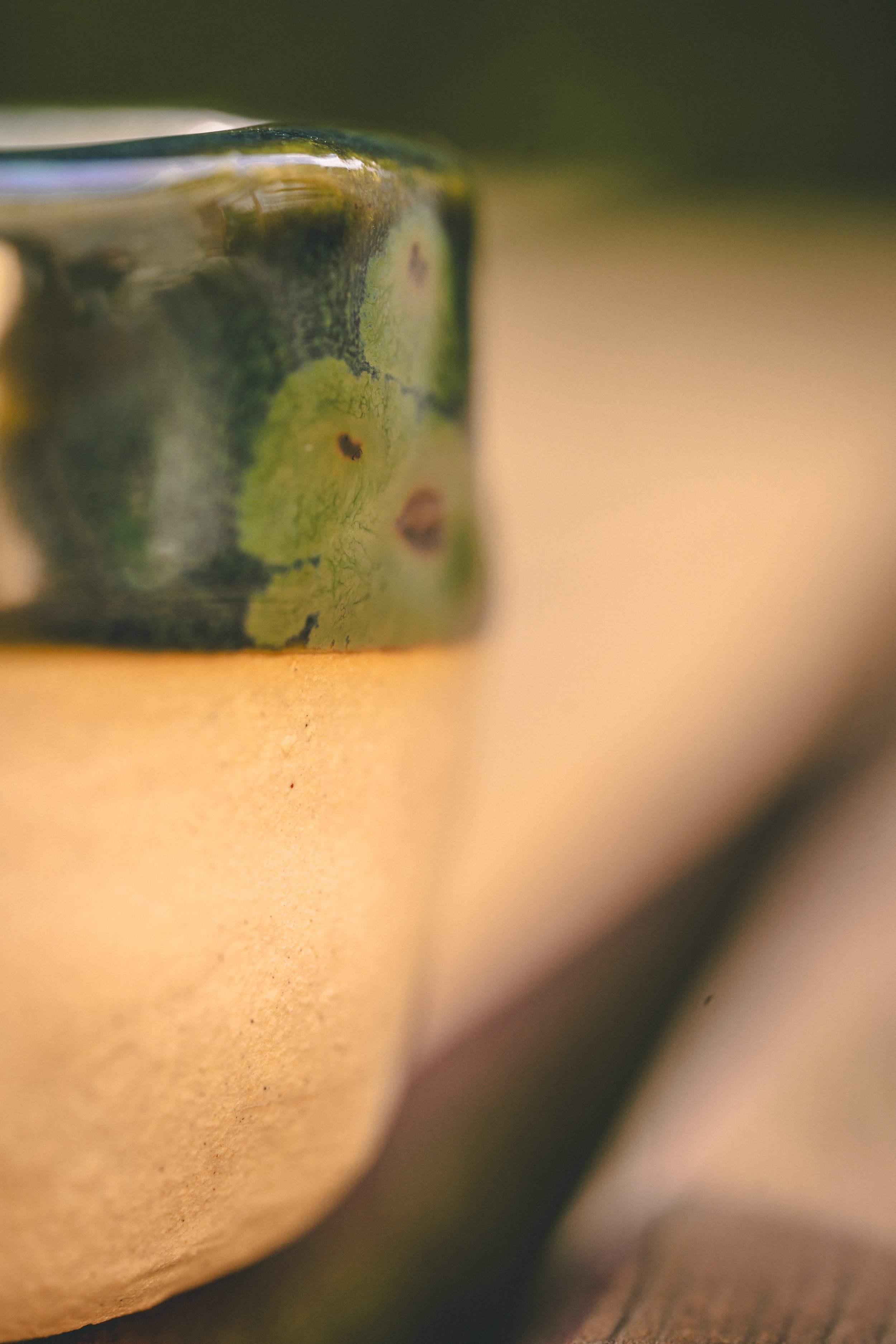 Ce vase en céramique brut, créé par Mégane Fiévez de MF Pottery, est une ode à l'imperfection et à l'authenticité. L'émail vert vibrant contraste avec la texture brute de la terre, offrant un objet décoratif unique. Julien Mathy, photographe spéciali