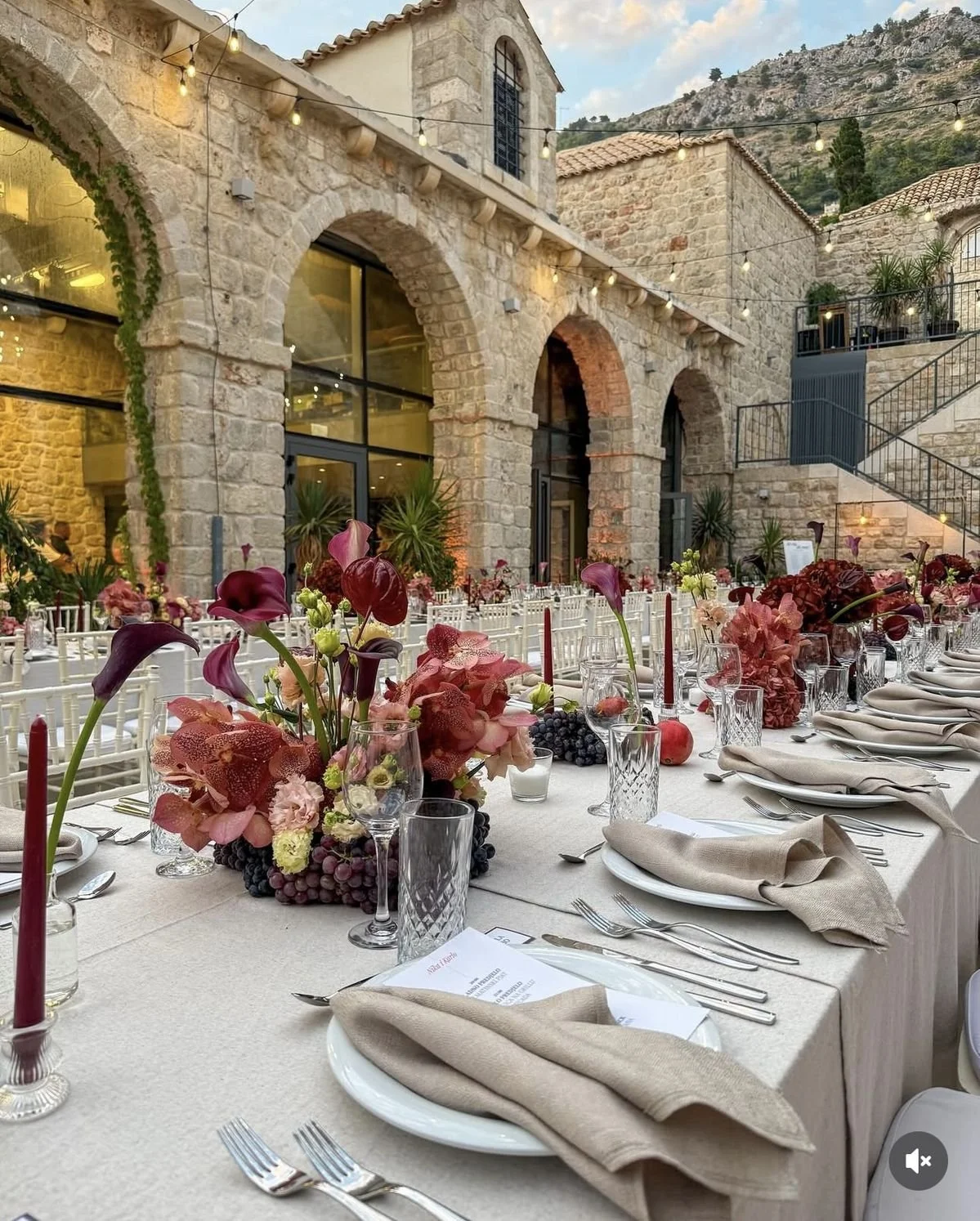 A round, modern floral centrepieces with calla lilies, orchids and purple grapes. Niagara wedding flowers
