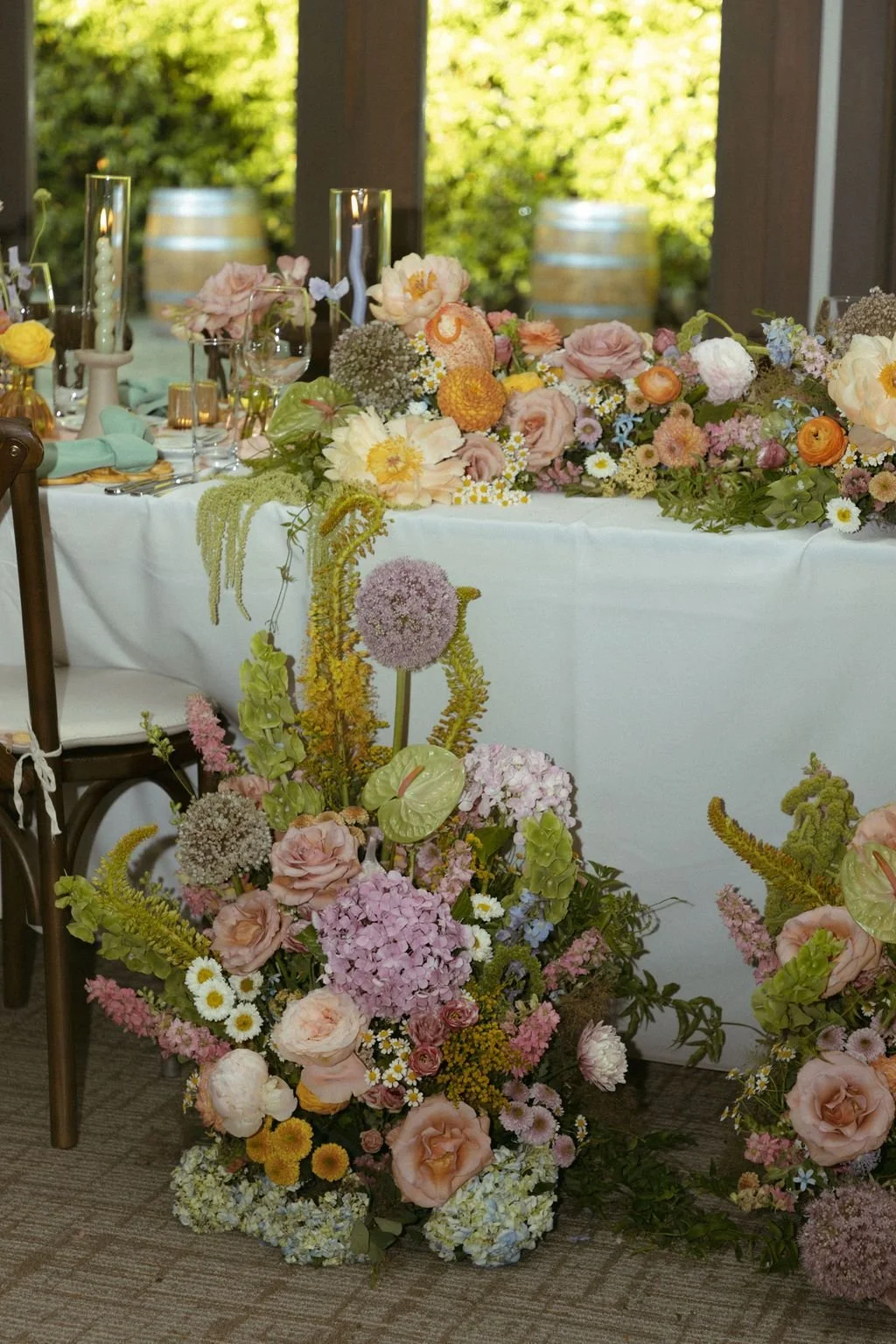 A modern floral arrangement filled with roses, hydrangea and anthrium in shades of peach, lavendar and green. Placed in front of a reception sweetheart table. Ontario wedding flowers