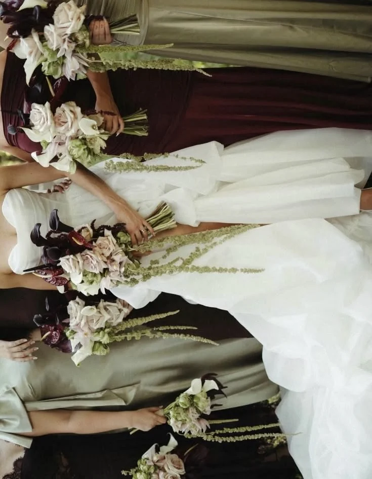 A Bride and bridesmaids in burgundy and sage green dresses, with modern bridal bouquets. Niagara wedding flowers