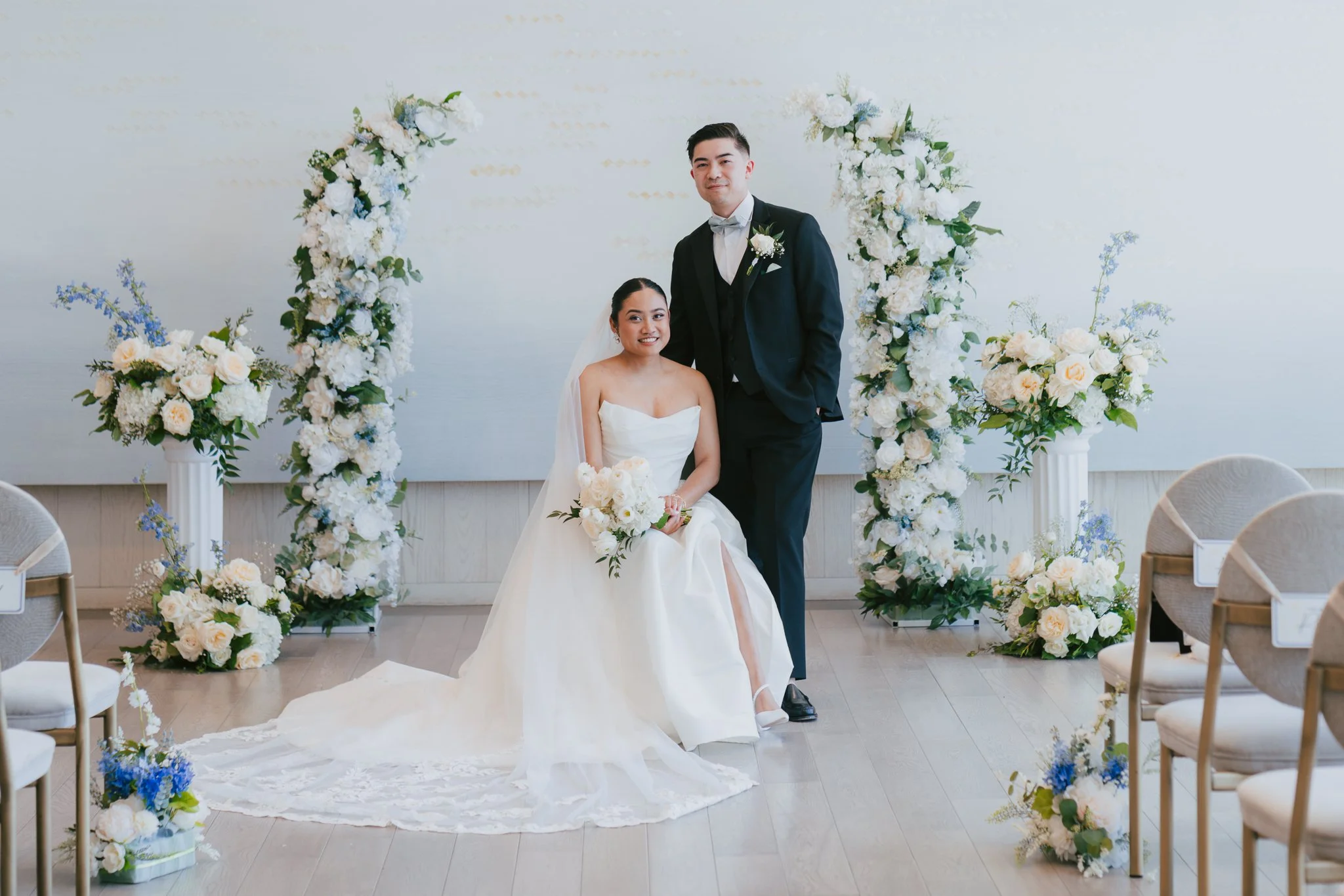 A Bride and Groom sitting in front of ceremony flowers at the Pearle Hotel and Spa