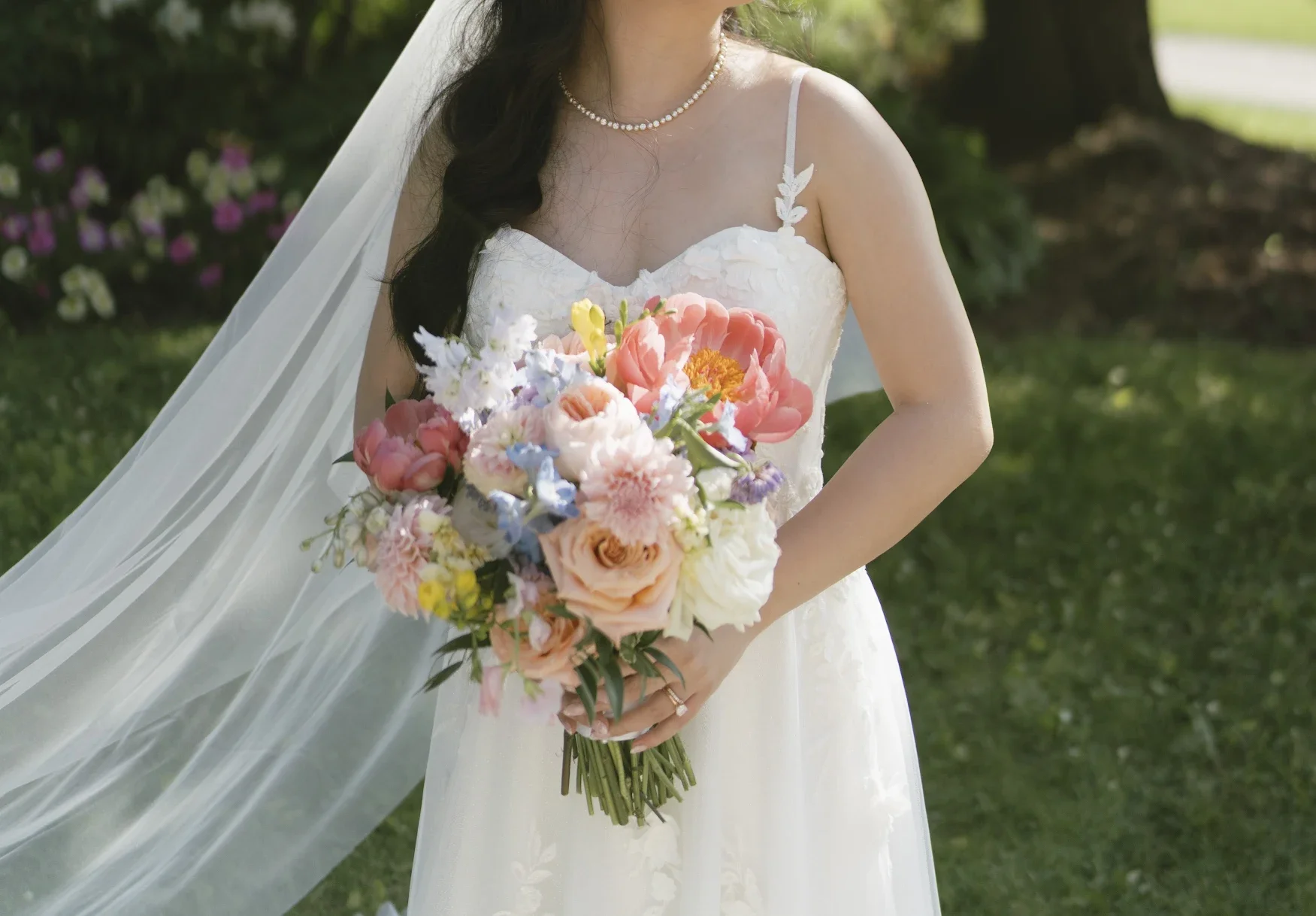A Bride holdinga  bouquet of bright summer flowers