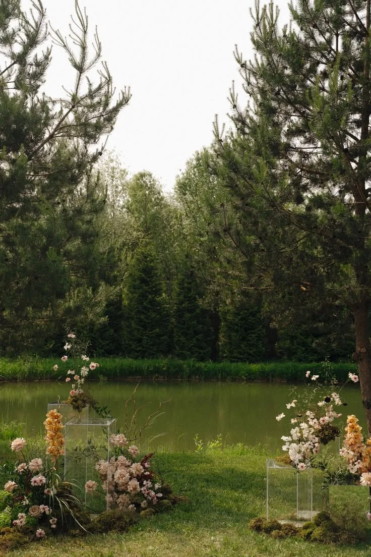 A wedding ceremony in front of lake with blush and brown flower arrangements. muskoka wedding flowers
