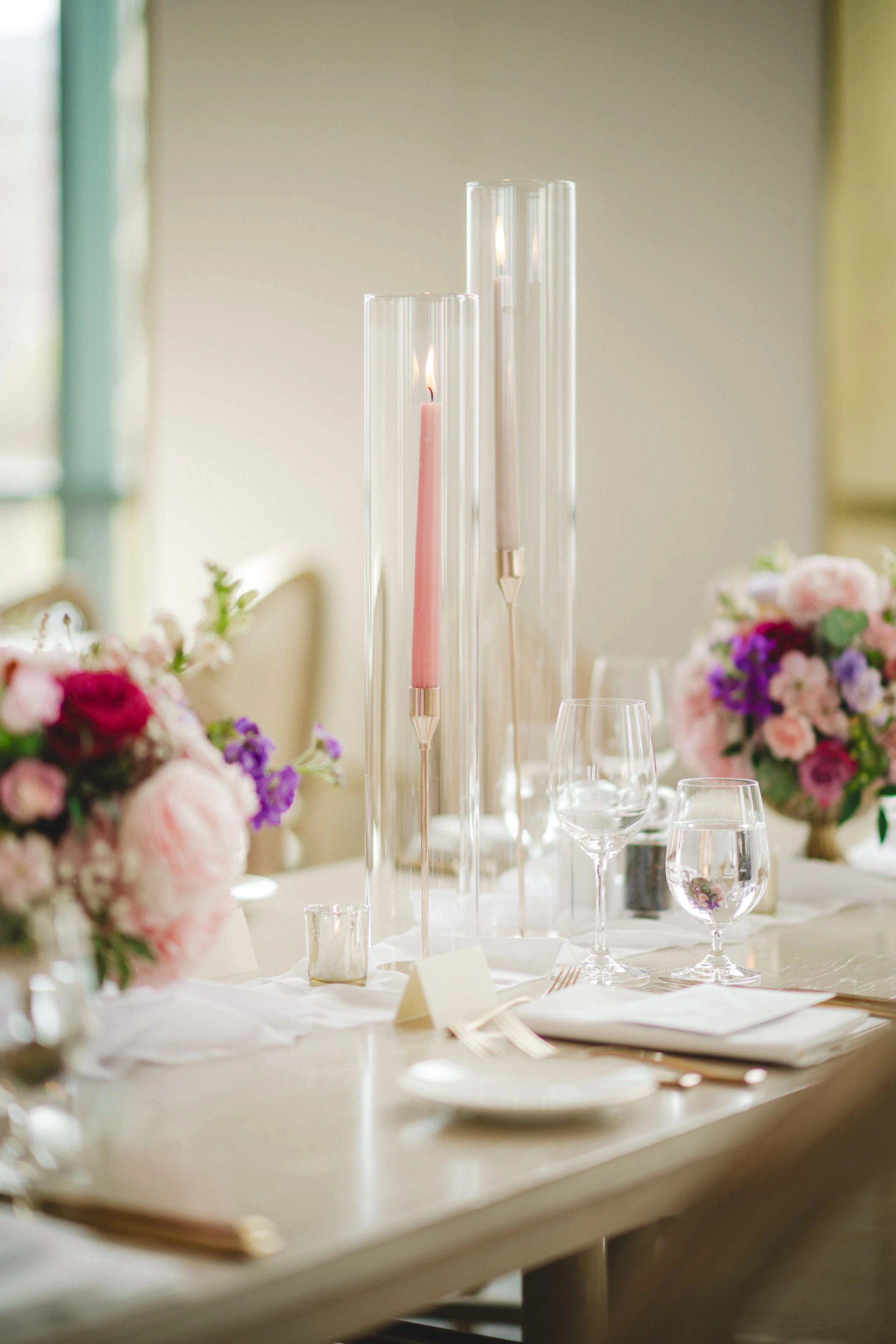 Pink and Purple Floral Centrepiece with taper candles at a wedding at the Pearle Hotel and Spa