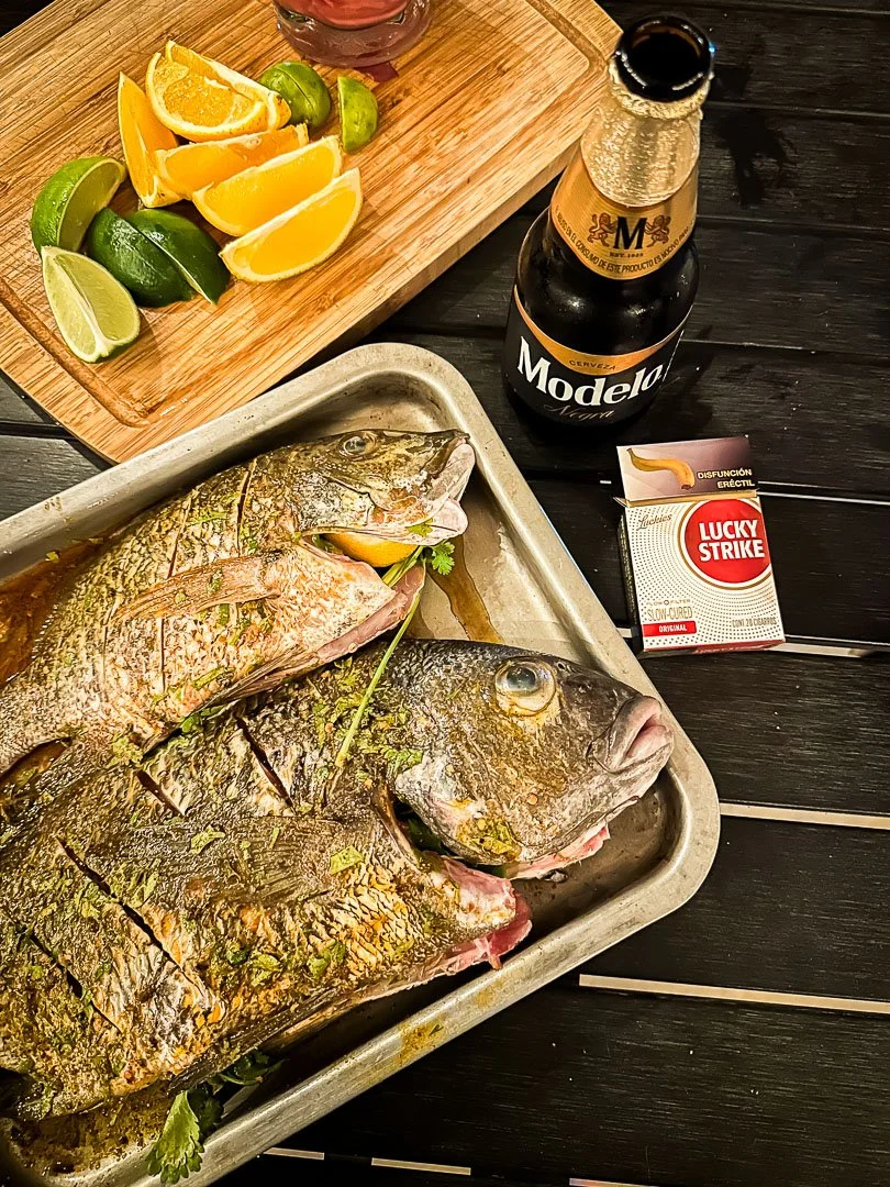 Fresh caught fish ready for the grill with a side of modelo and lucky strikes
