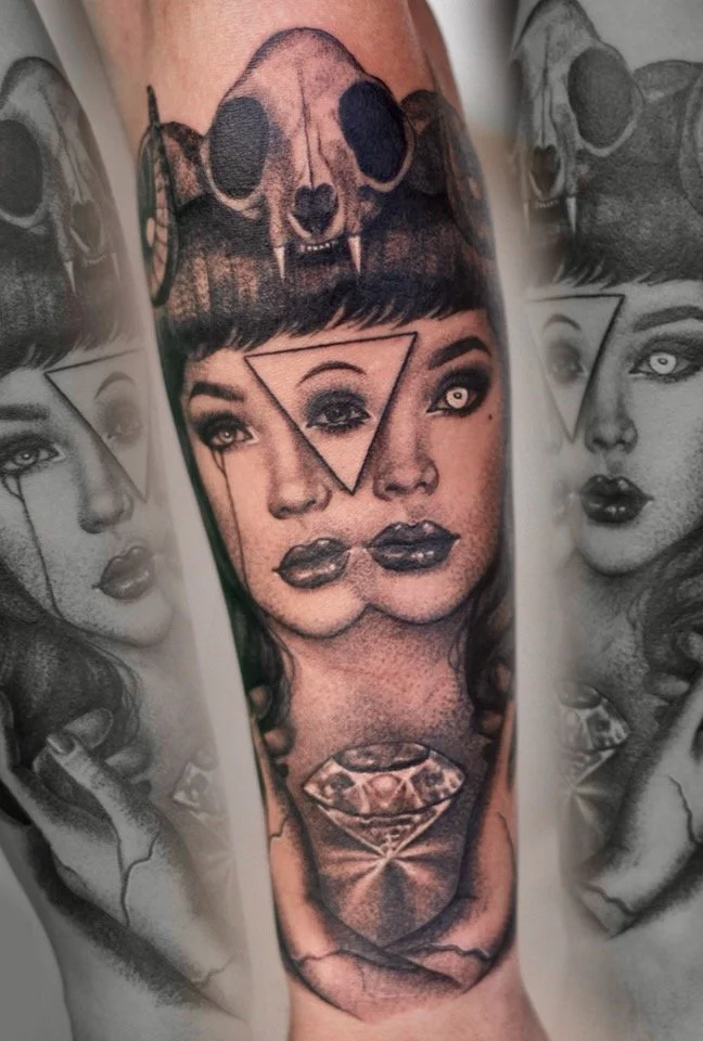 Surreal black-and-grey portrait tattoo with overlapping faces, an animal skull, and a diamond, by Colina.