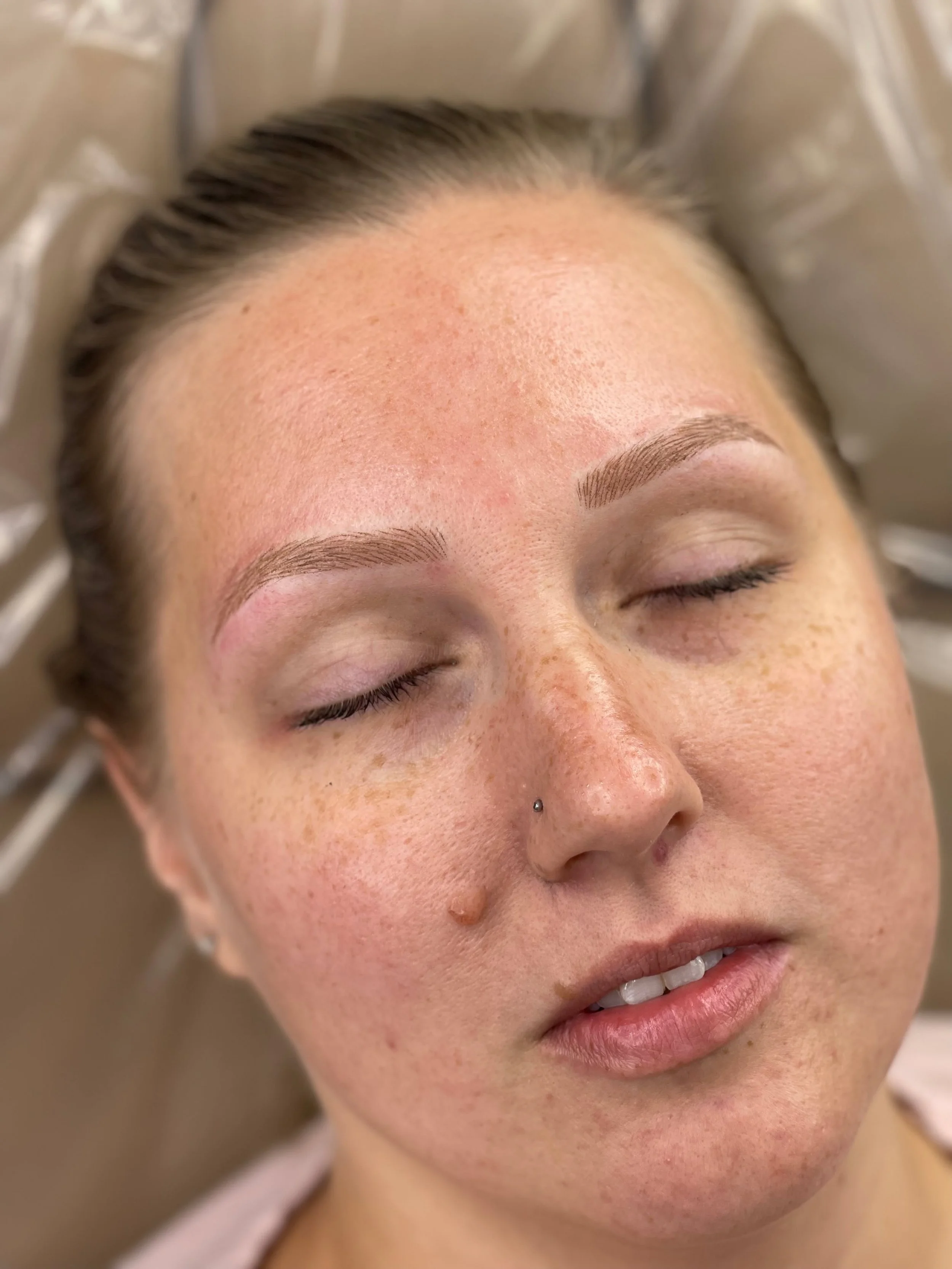 Client with completed soft powder brows after brow mapping.