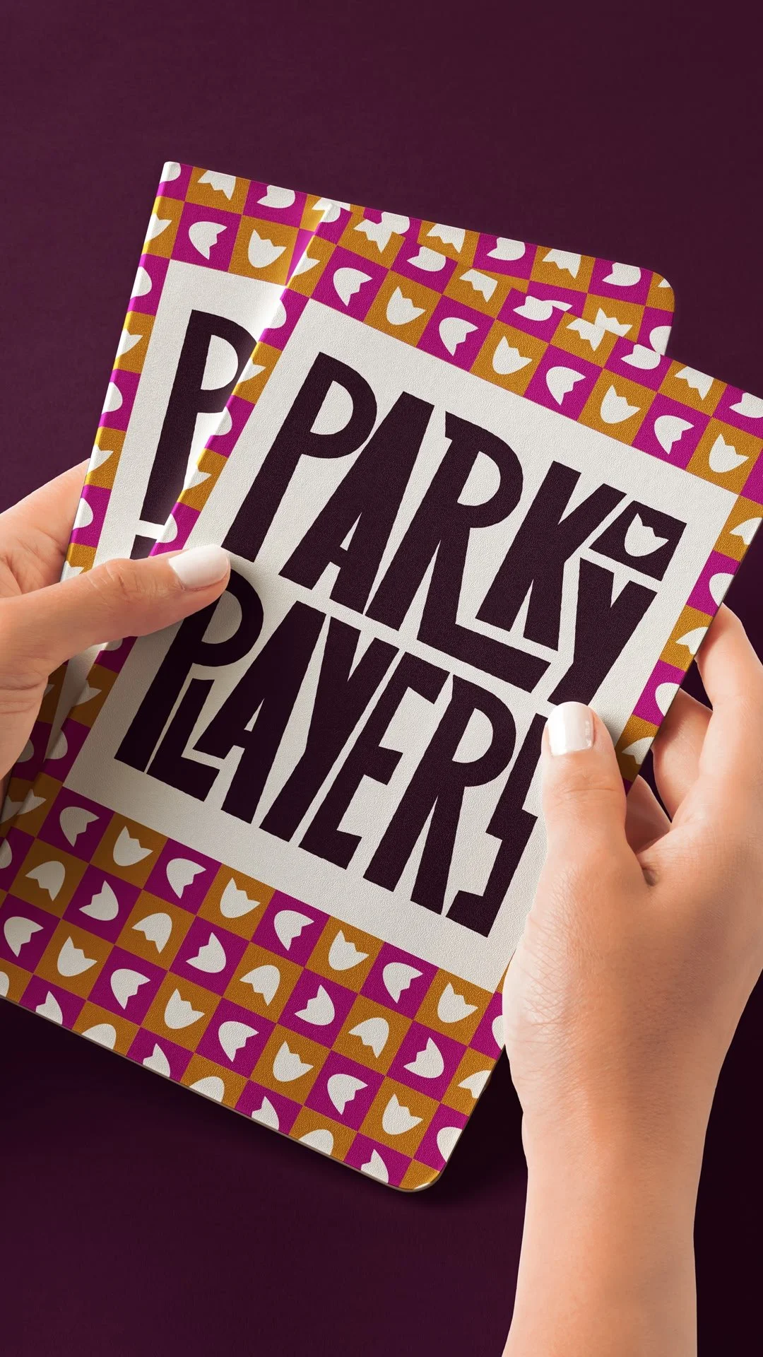 Two people holding a card with the message 'Parky Players' on it, with a colorful border pattern of purple, white, and gold shapes.