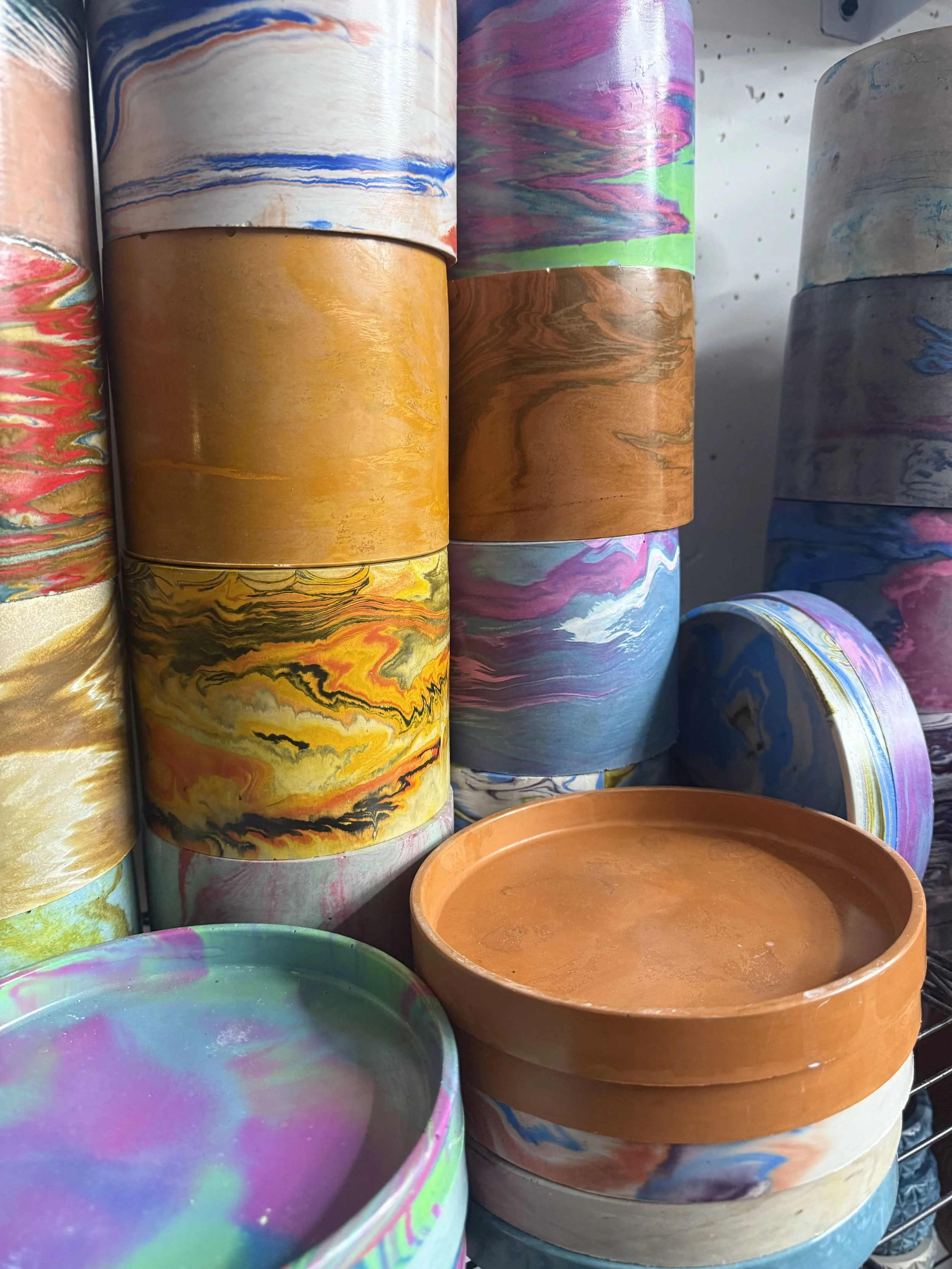 Handmade cement planters colorful terrazzo pots custom home decor and plant gifts made in St Augustine Florida. Stacked and colorful in 6 inch planter pot size with matching drip tray dish for water handmade colorful unique coastal fun garden gifts