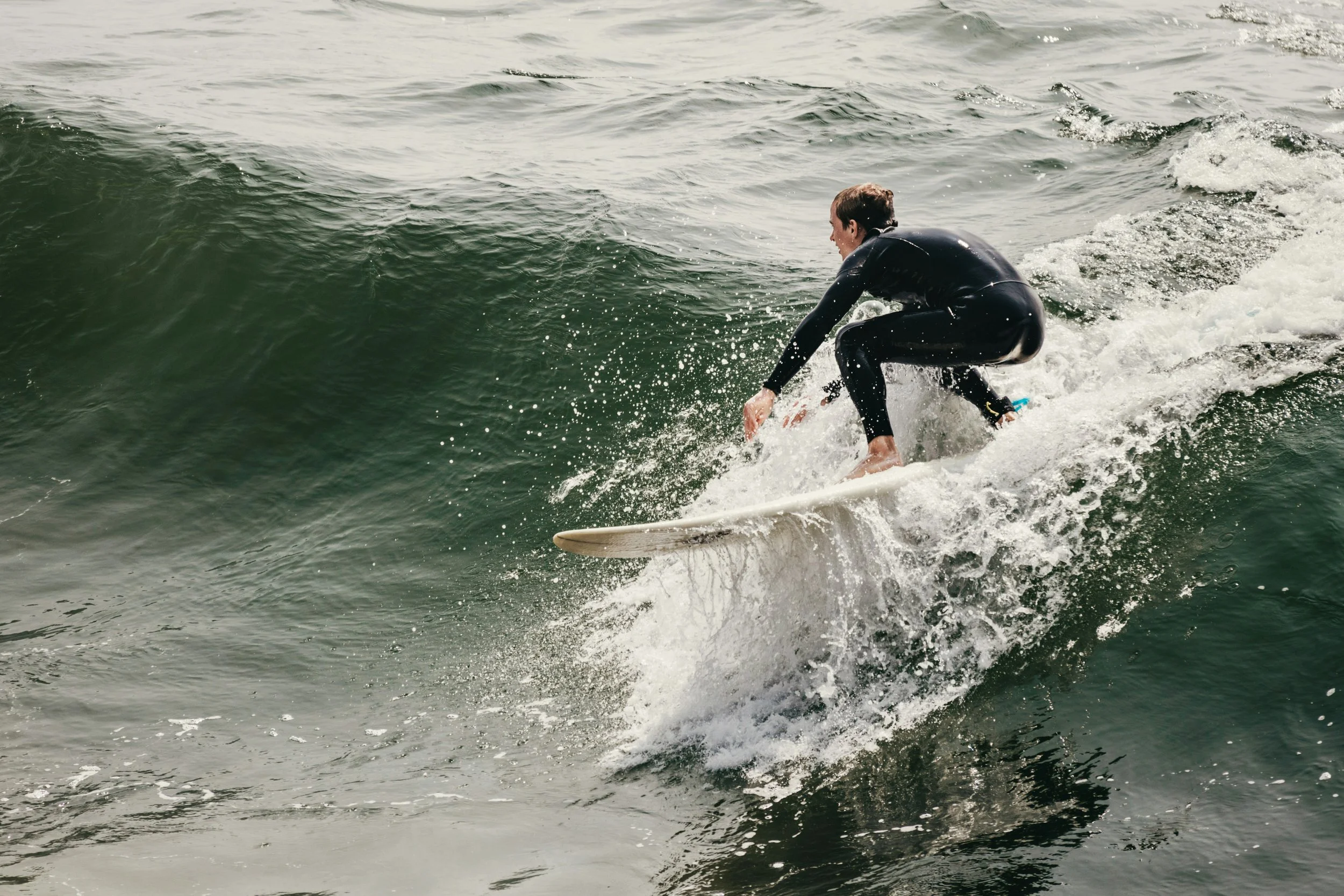 Person surfing on a wave in the ocean.
