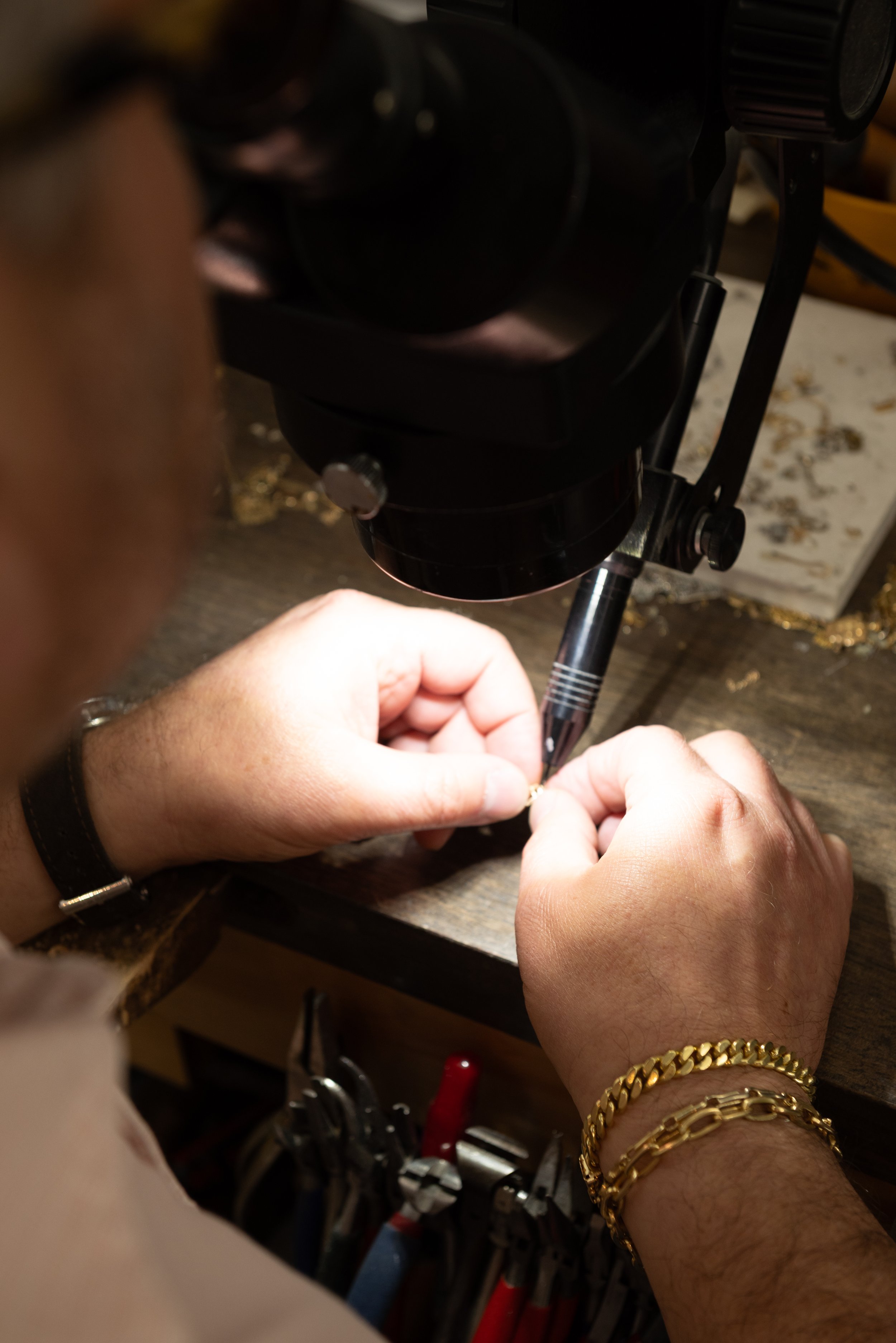 Jeweler working under magnification on a fine jewelry piece at Brilliant Fine + Custom Jewelry in Roswell.