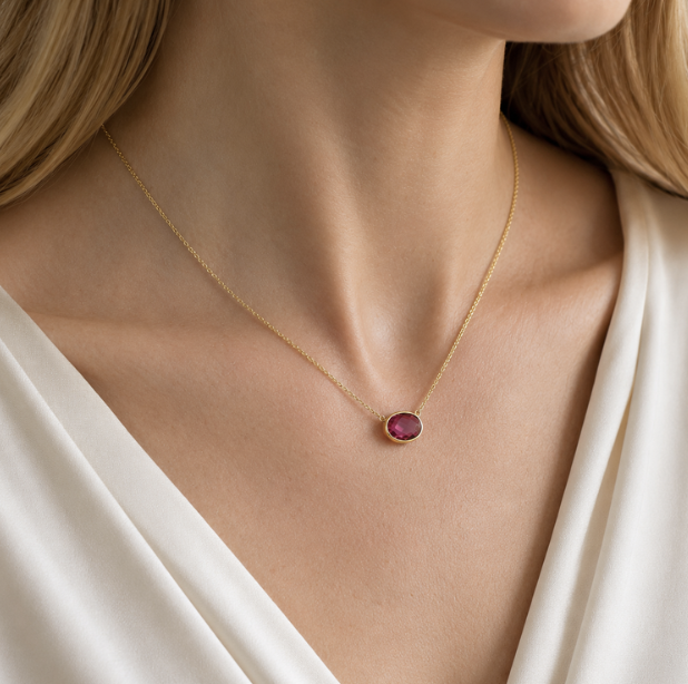 A Ruby birthstone pendant set in yellow gold on a yellow gold box chain. A perfect piece to represent the arrival of a child from Brilliant Fine+Custom.
