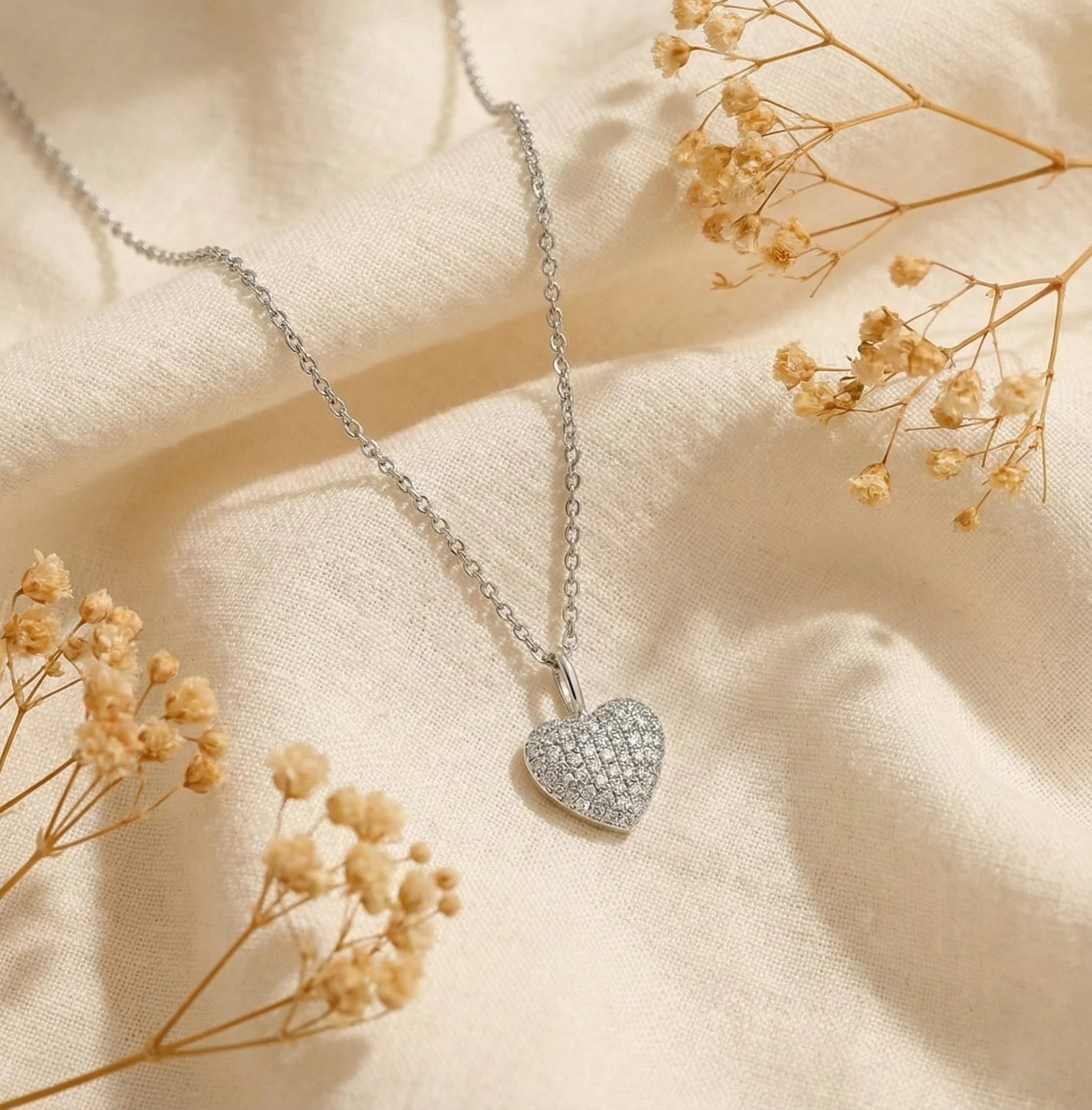 A pave diamond heart-shaped pendant on a white gold chain from Brilliant Fine+Custom jewelry.