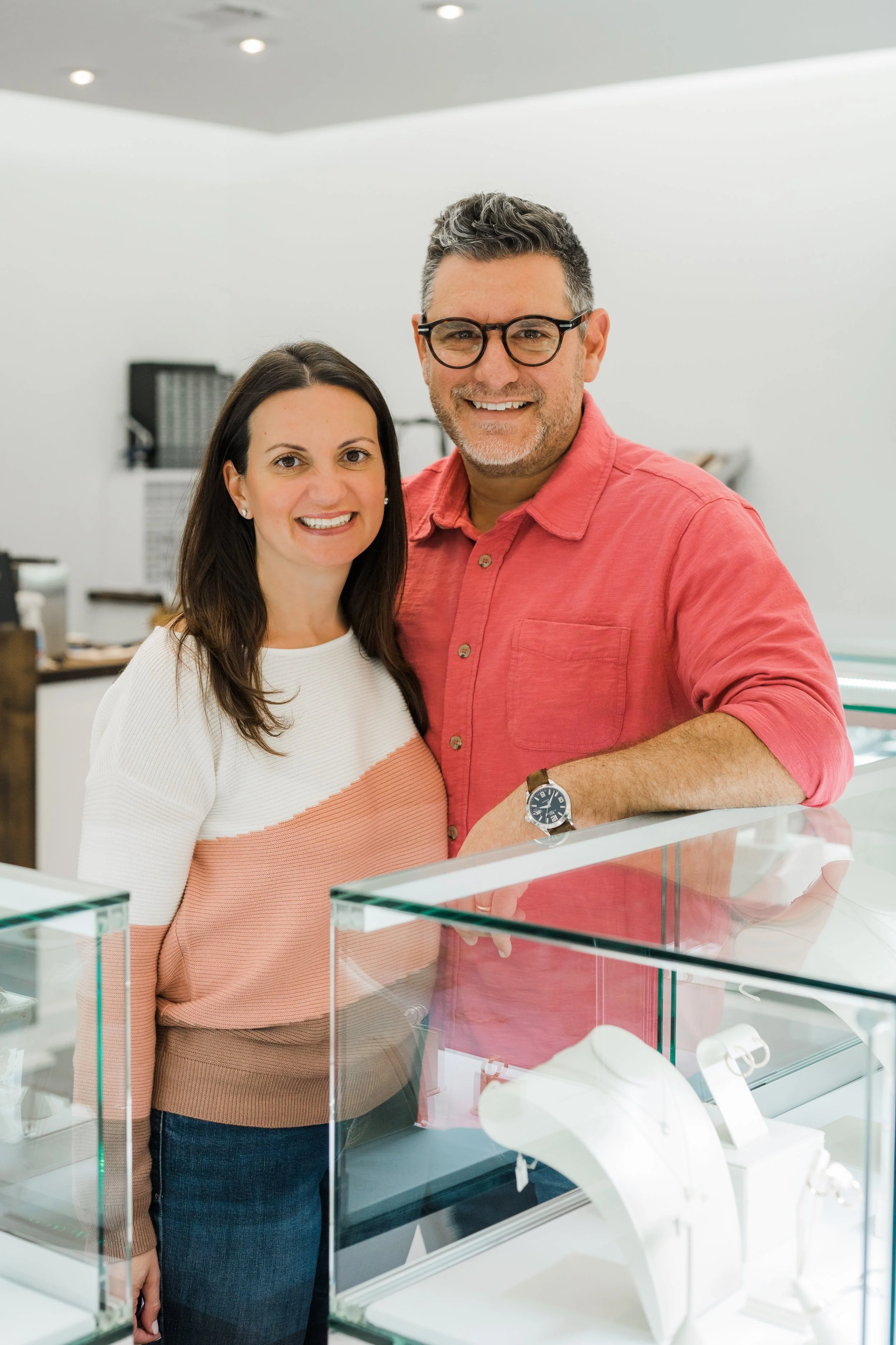 A photo of Katie Jaffe, standing next to Jamie, curating fine jewelry at Brilliant Fine + Custom Jewelry in Roswell, Georgia