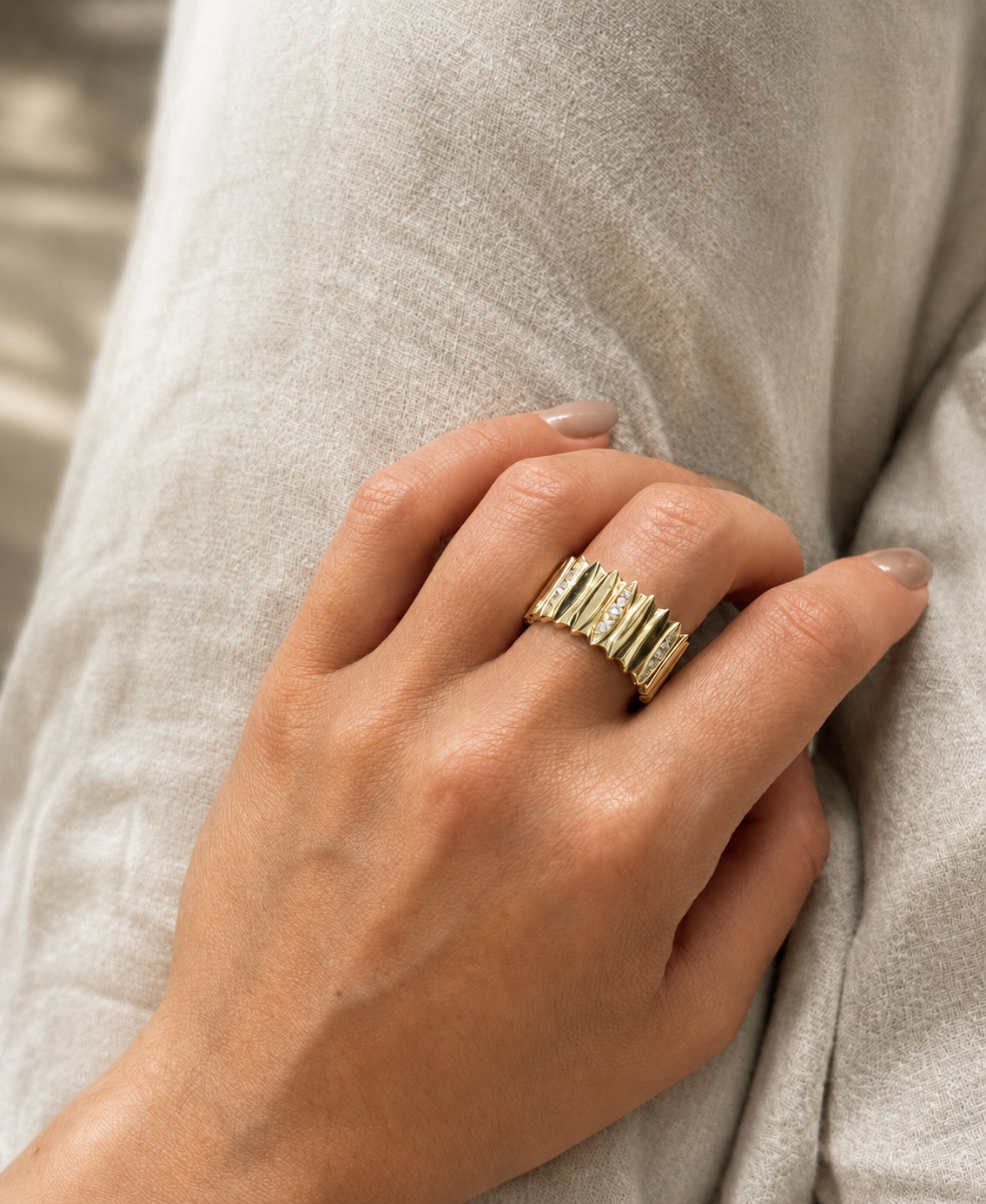 A wide cigar-band style ring with accent diamonds from Brilliant Fine+Custom Jewelry.